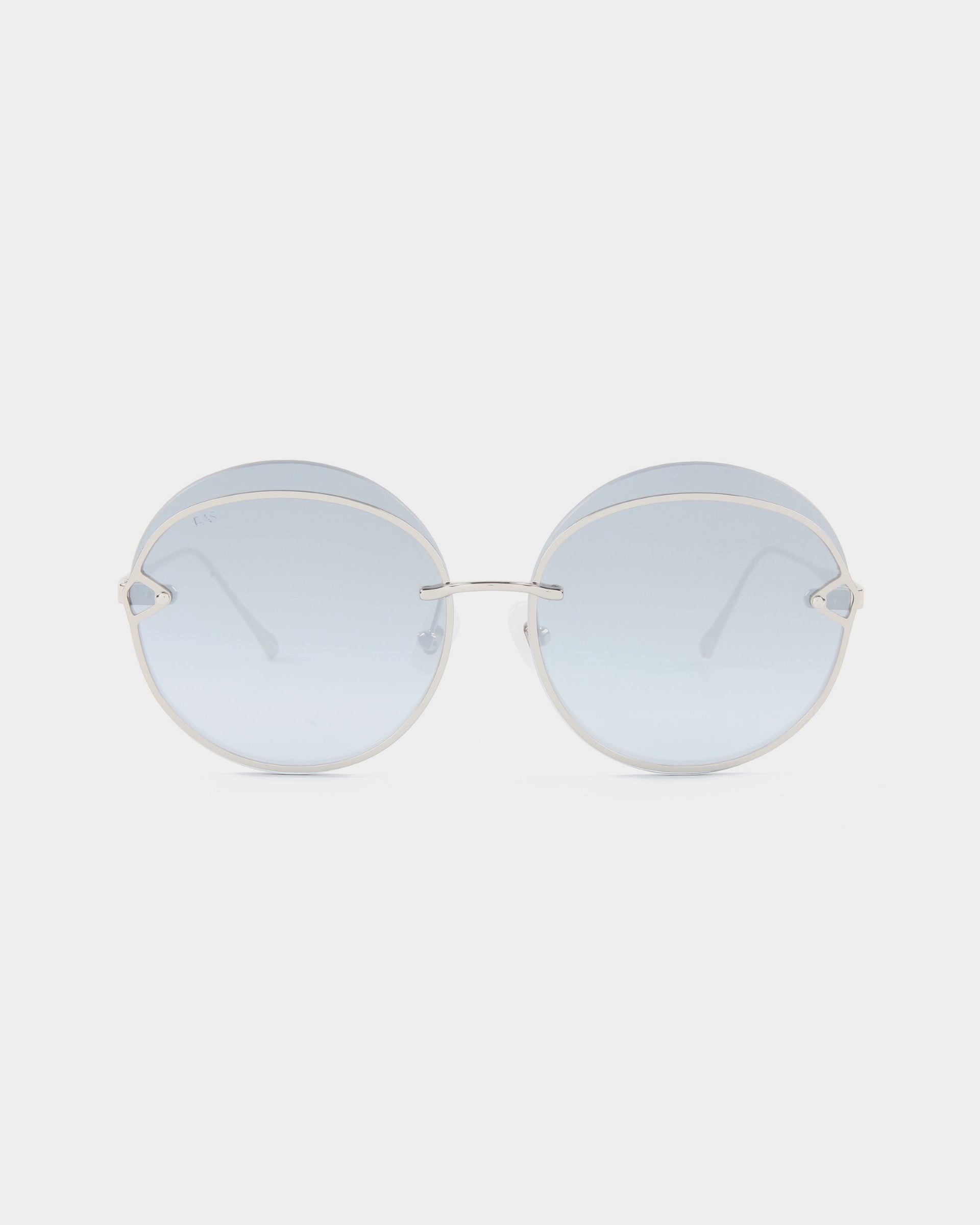 A pair of Quartz sunglasses by For Art's Sake® featuring round, frameless lenses with a light blue nylon tint. These minimalist and modern sunglasses are designed with thin stainless steel temples and a simple bridge, providing stylish UVB protection for sunny days.