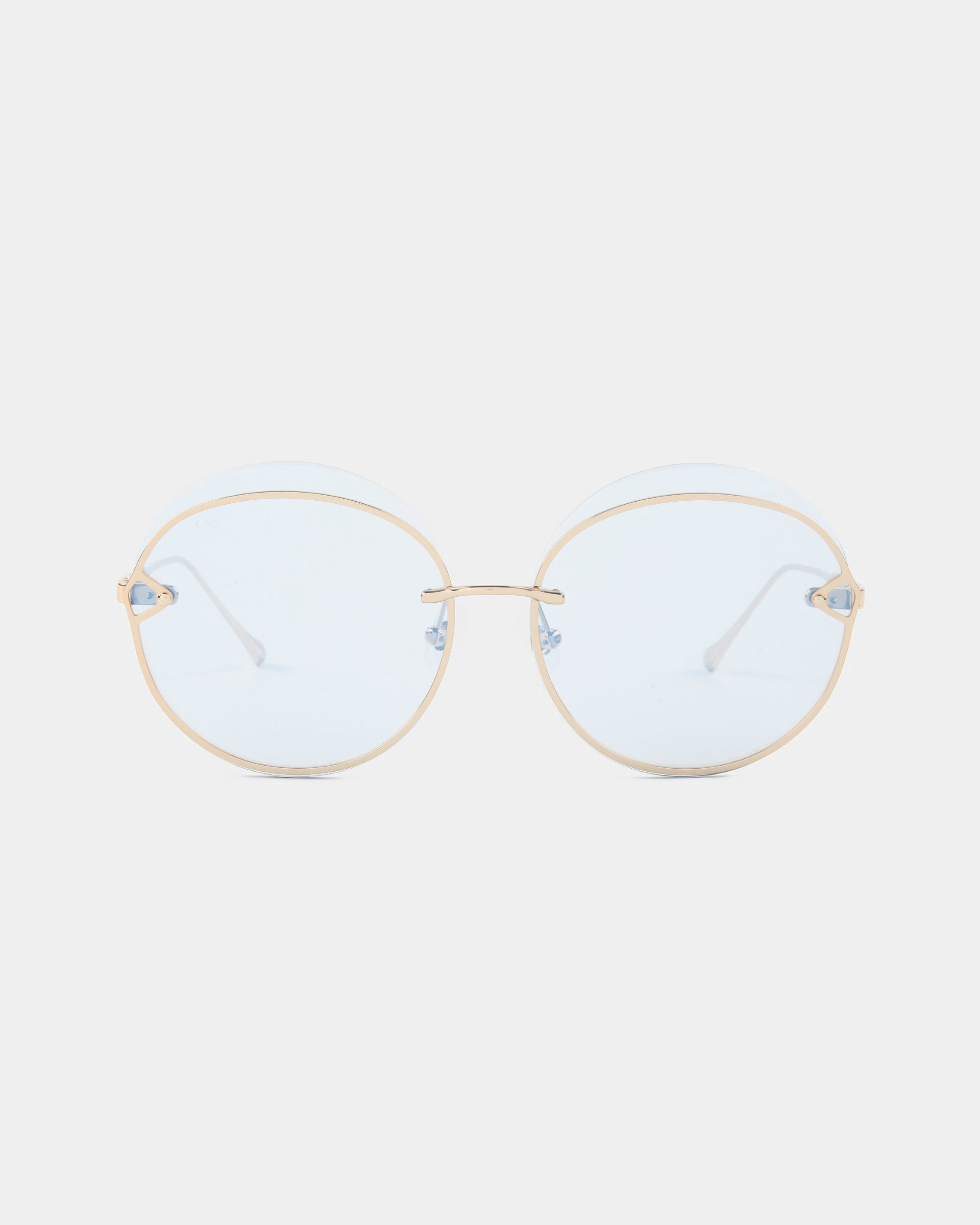 The "Quartz" eyeglasses by For Art's Sake® are a pair of gold-rimmed, round spectacles with clear nylon lenses. The delicate stainless steel frames boast a thin, lightweight design and adjustable nose pads. Positioned against a plain white background, these glasses perfectly blend elegance with functionality.