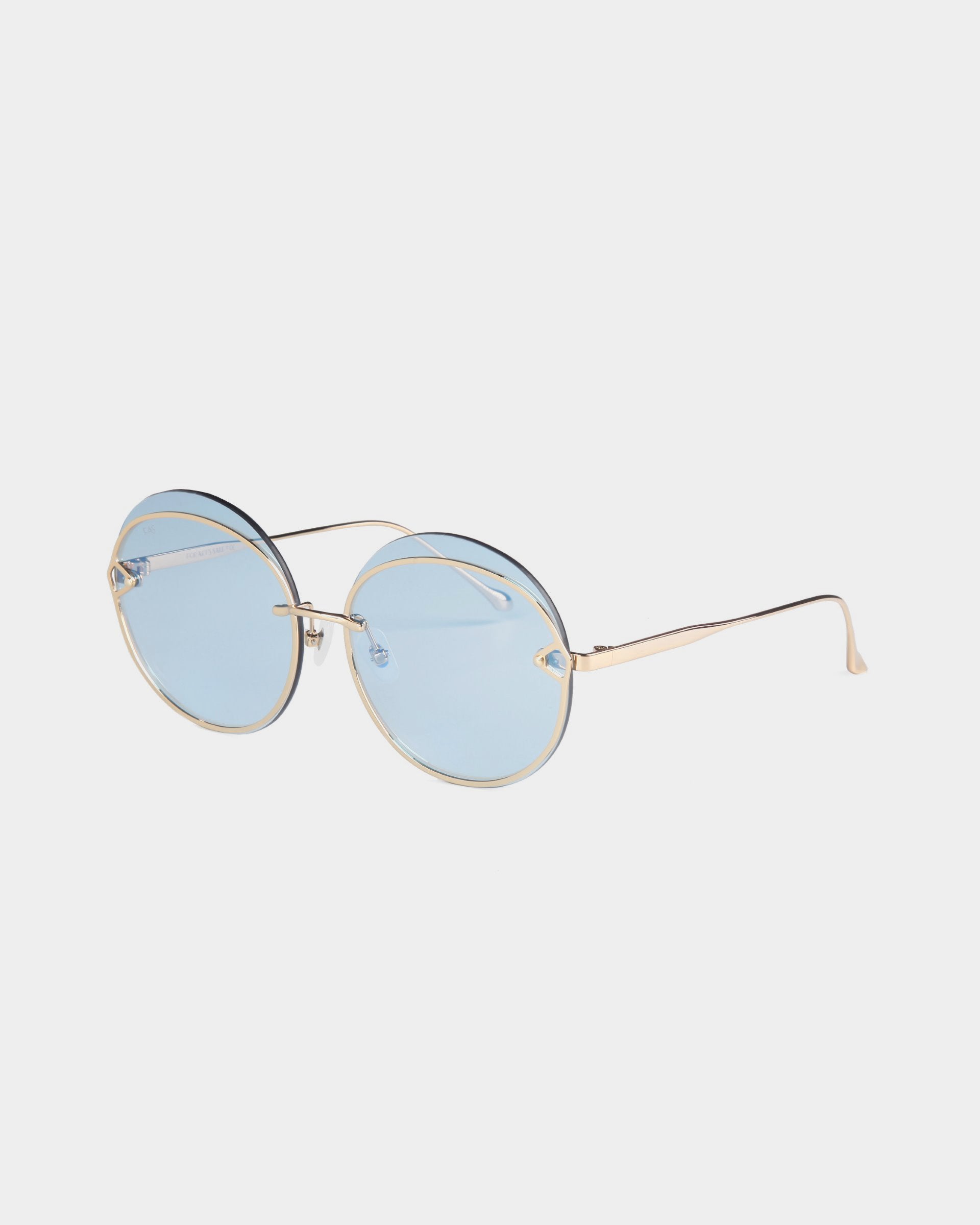 Introducing the Quartz sunglasses by For Art&#39;s Sake®: These stylish shades feature round lenses with a light blue tint and UVB protection. The minimalist design includes thin, gold-colored stainless steel frames and slightly reflective lenses, complete with curved temple tips for a secure fit.