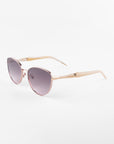 A pair of stylish Frida Brush sunglasses by For Art's Sake® with pink-tinted, ultra-lightweight lenses and a light pink frame. The arms of the glasses are also light pink and slightly angled outward, ensuring comfort. With UVA & UVB protection, these Frida Brush sunglasses by For Art's Sake® are photographed against a plain white background.