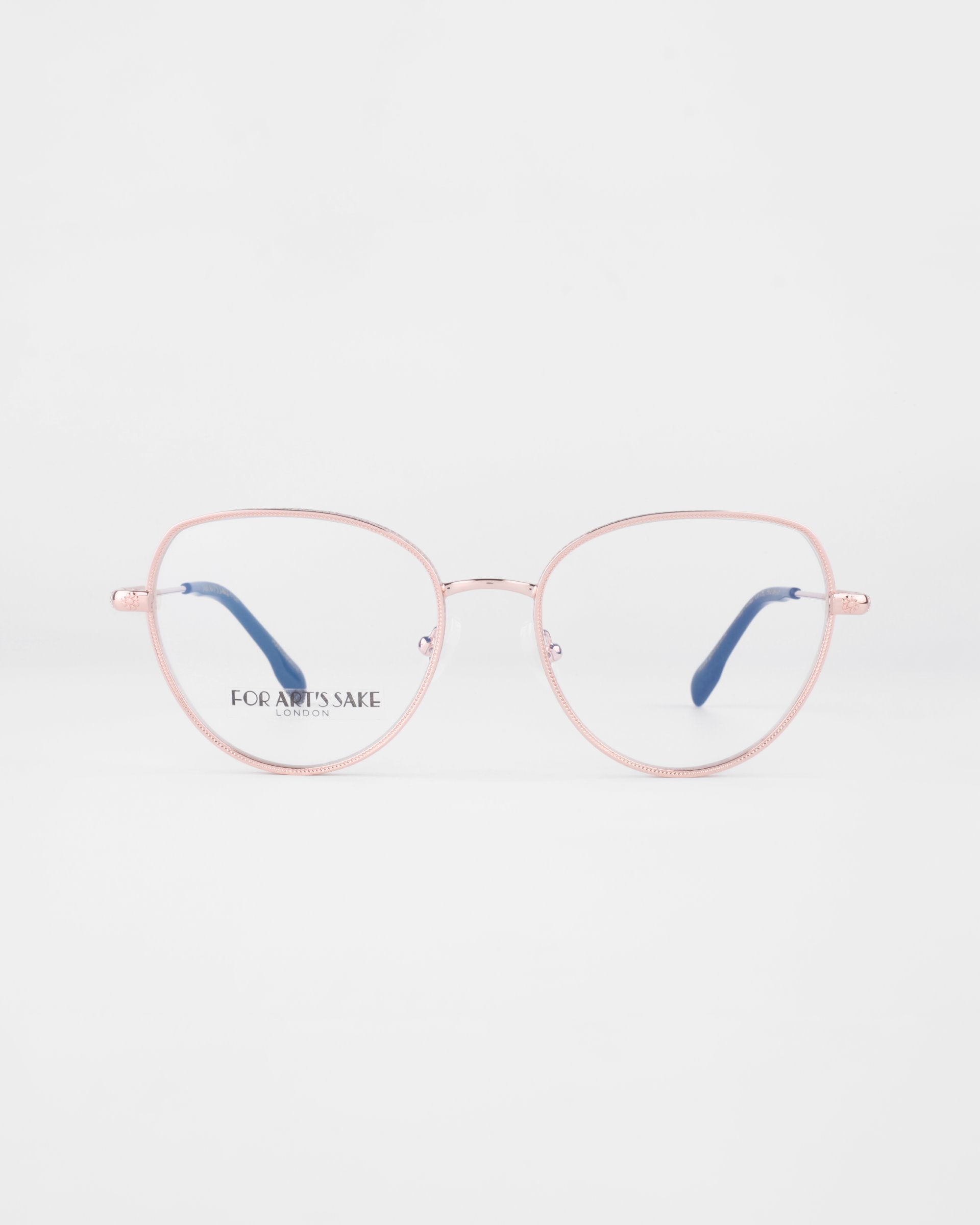 A pair of Frida Floral eyeglasses from For Art&#39;s Sake® with pink metal frames and round lenses on a plain white background. The earpieces are slender and slightly curved. Featuring 18-karat gold-plated frames, the words &quot;FOR ART&#39;S SAKE&quot; are visible on the inner side of the right lens.
