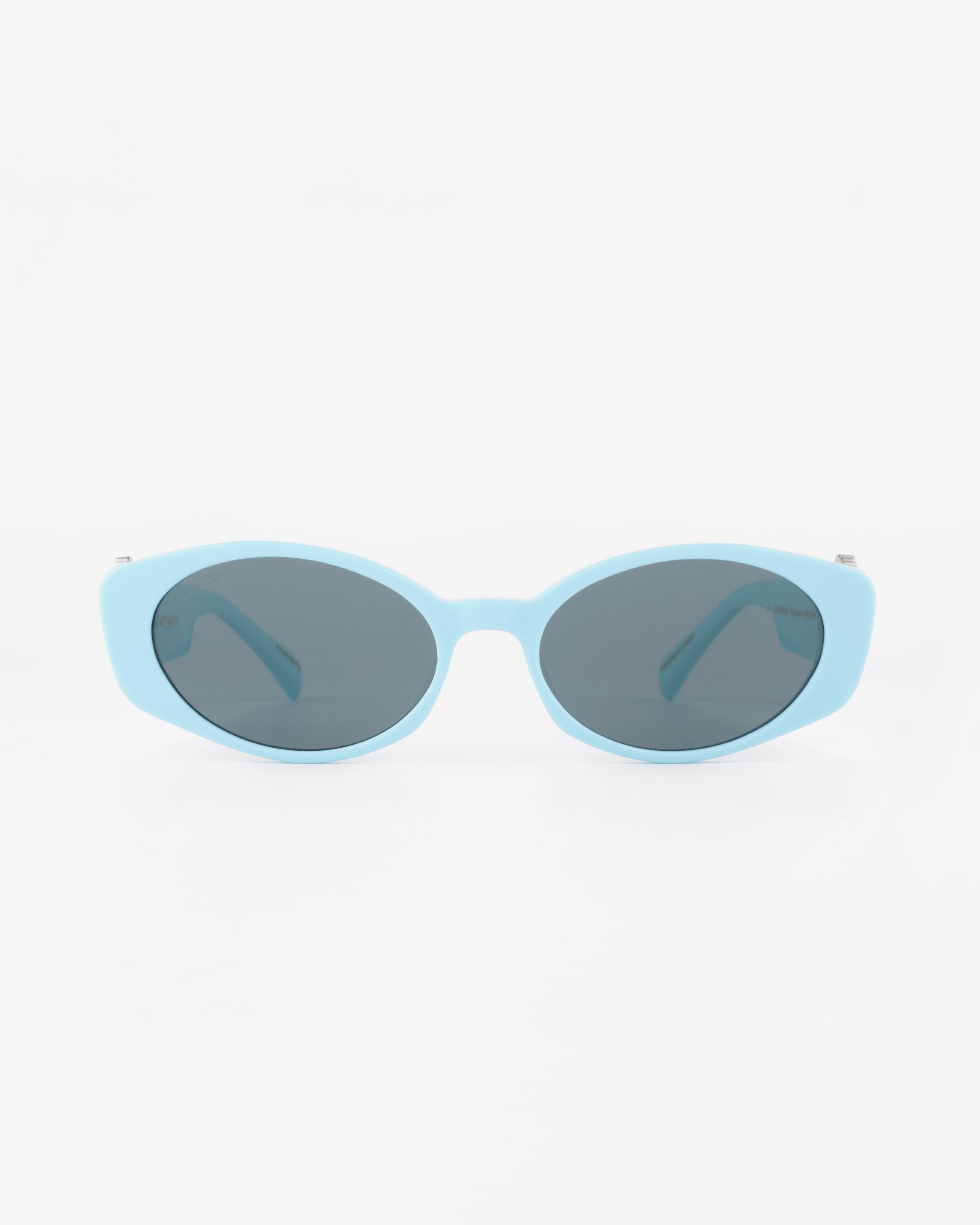 A pair of light blue oval sunglasses with dark tinted, ultra-lightweight nylon lenses offering 100% UVA &amp; UVB protection. The background is plain white, making the For Art&#39;s Sake® Frida Portrait sunglasses the focal point of the image.
