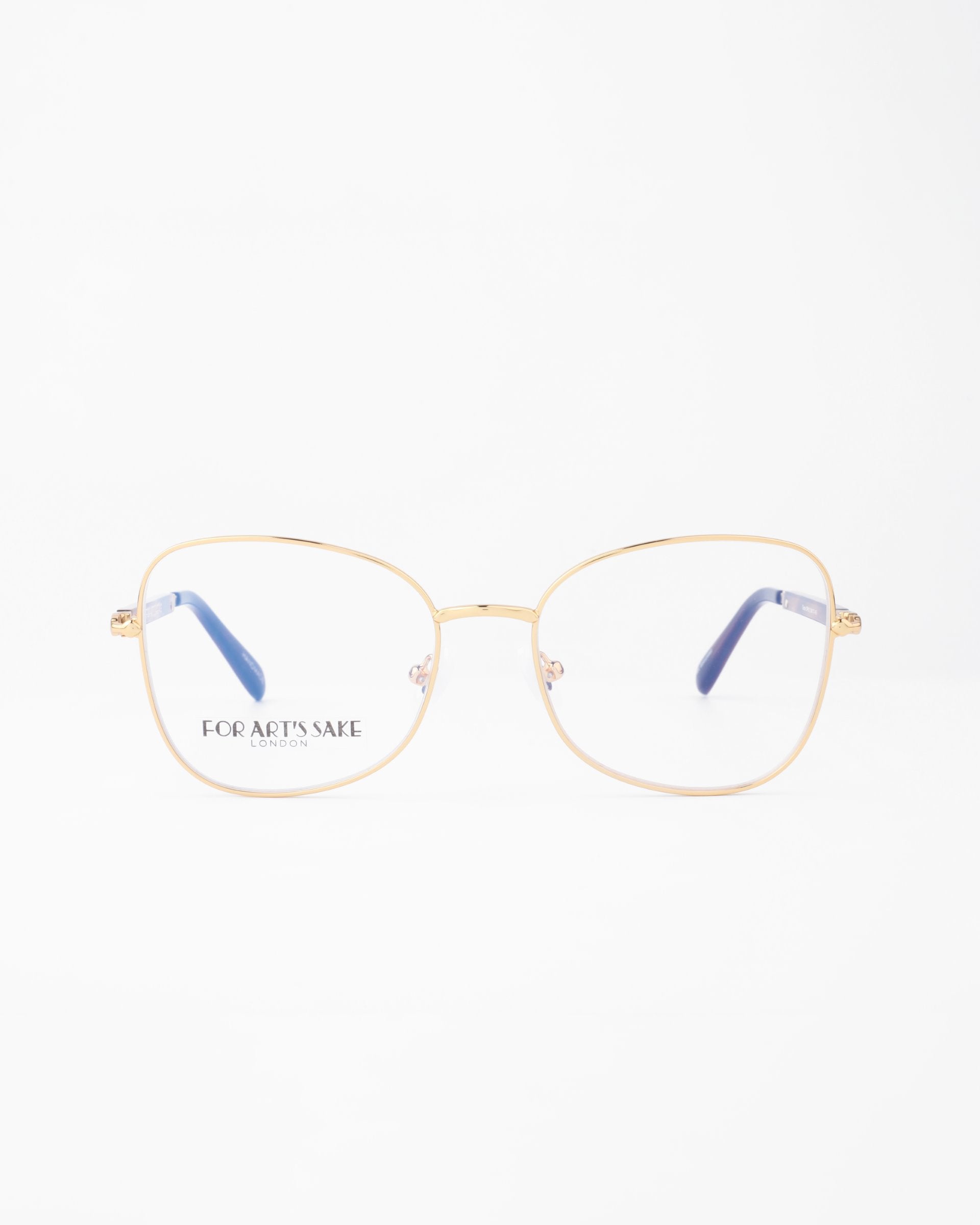 Front view of a pair of gold-framed eyeglasses with square lenses and blue temple tips, set against a plain white background. The 18-karat gold-plated Grace glasses have the brand name &quot;For Art&#39;s Sake®&quot; displayed on the left lens.