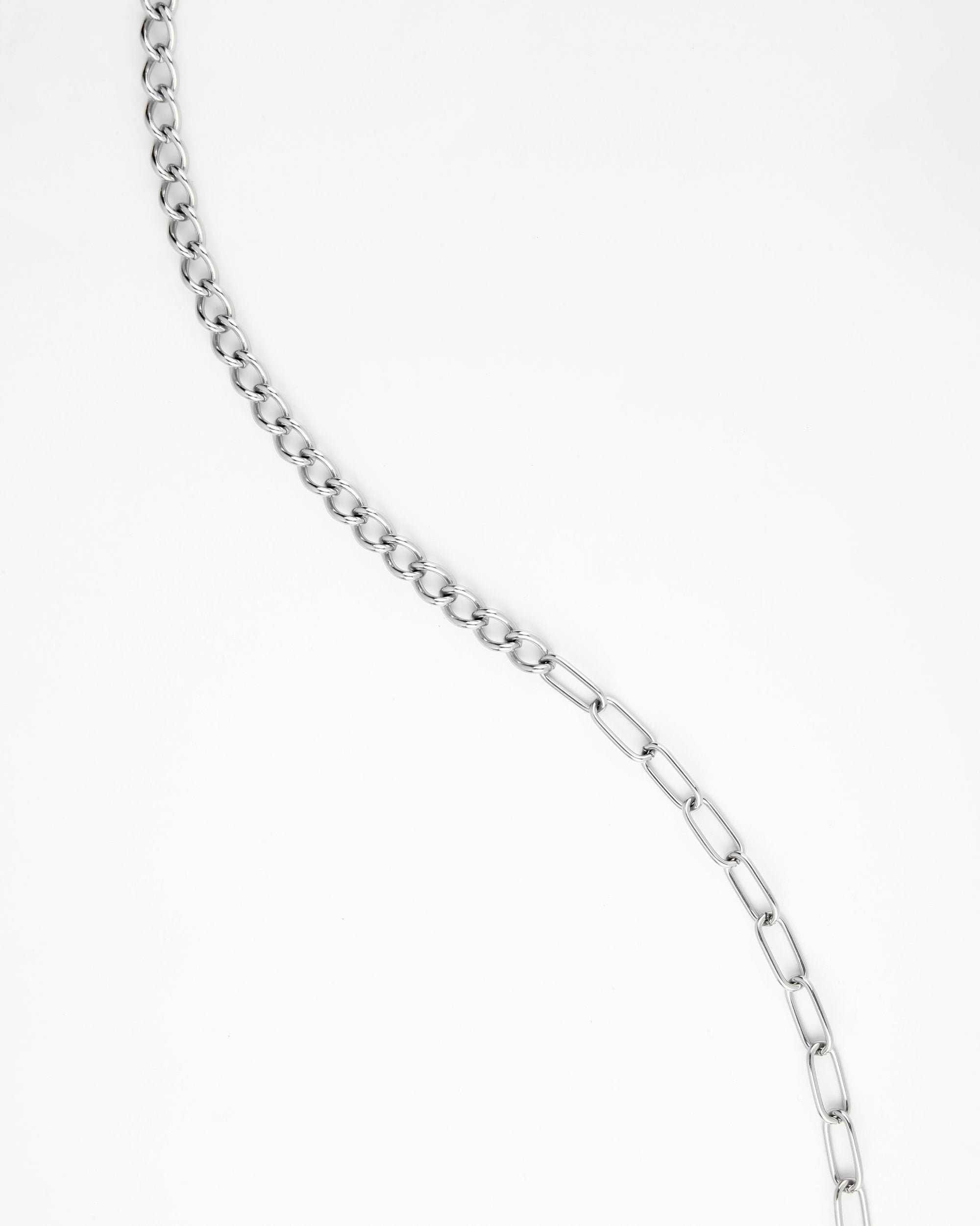 A For Art&#39;s Sake® Gabriel Glasses Chain with alternating smaller circular and larger rectangular links is displayed against a white background. The 18K gold-plated chain is arranged in a wavy pattern from the top left to the bottom right of the image.