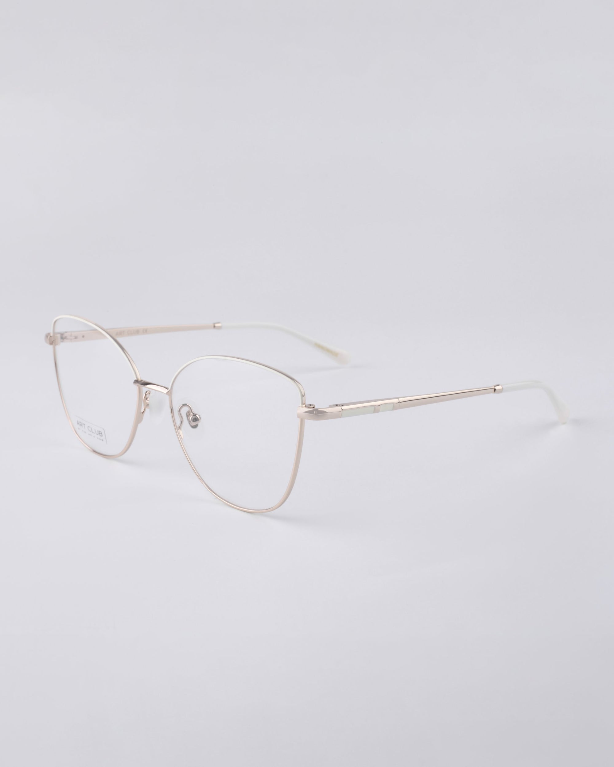 A pair of Greta frames by For Art&#39;s Sake®, featuring thin metallic edges and blue light filter lenses, is displayed against a plain white background. These glasses offer a minimalist and modern design, seamlessly combining sustainable luxury with functionality.