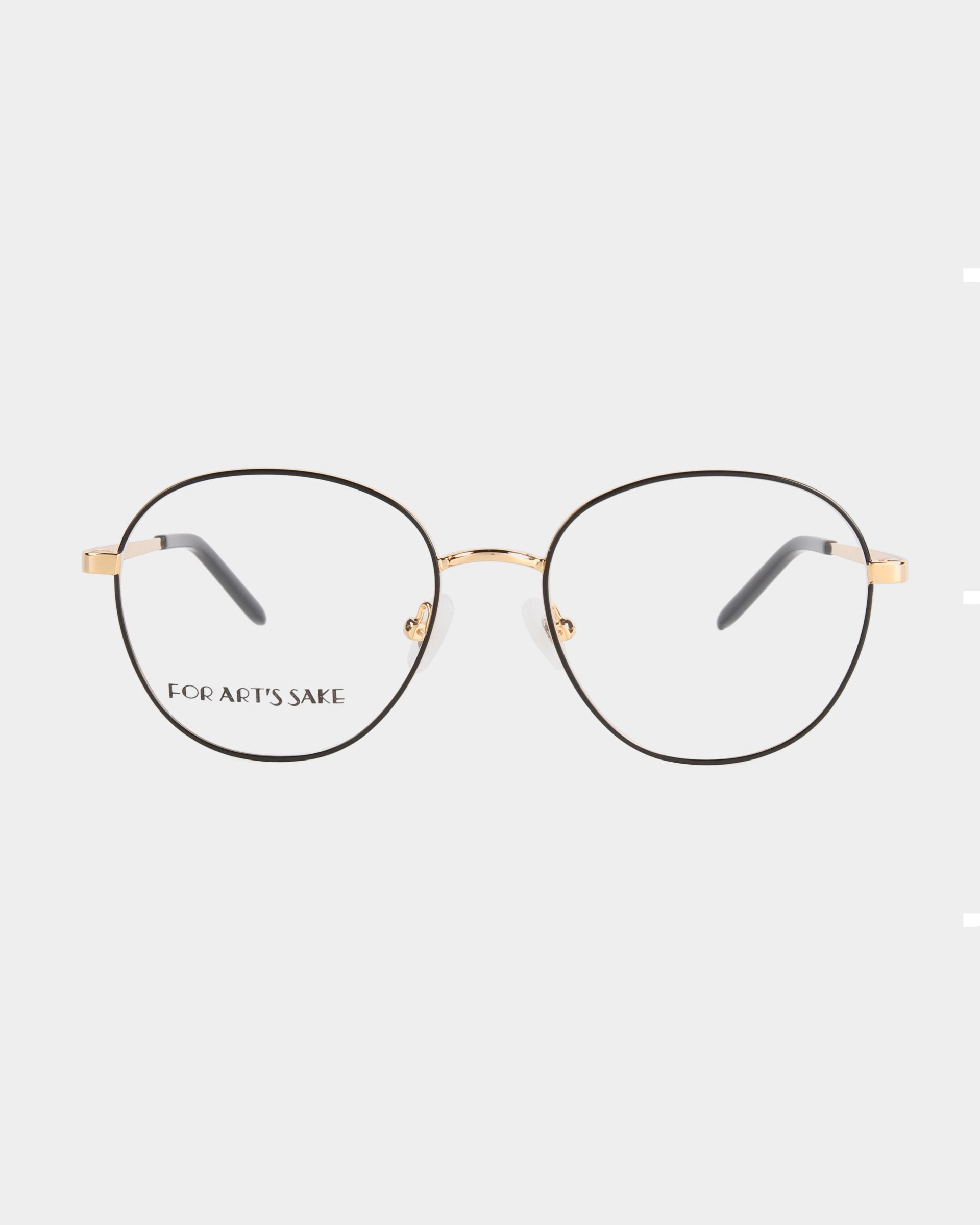 A pair of round, thin-framed eyeglasses with gold rims and black temple tips. These stylish glasses feature adjustable nose pads for a perfect fit and a minimalist design with clear lenses. The small inscription "For Art's Sake®" graces the left lens, adding a unique touch to the Hailey model.