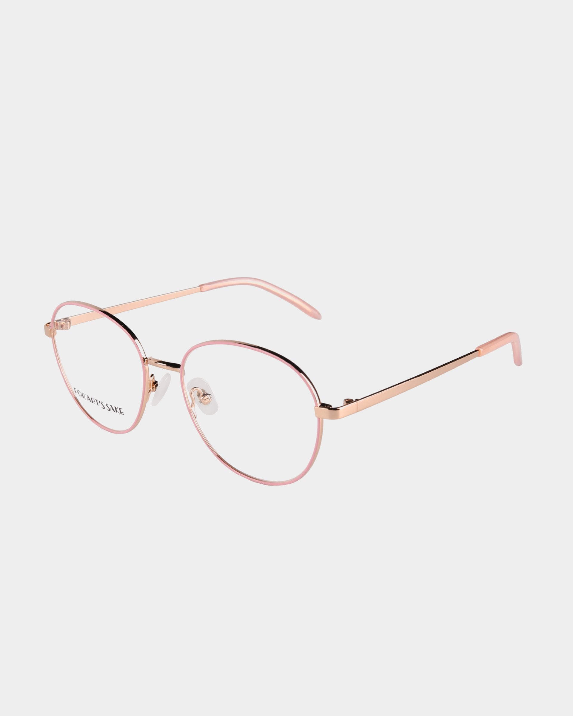 A pair of stylish eyeglasses with round pink frames, thin gold arms, and adjustable nose pads. The clear lenses feature a Blue Light Filter, and the ends of the arms are pink, complementing the frame color. These glasses come with an optional Prescription Service and are set against a plain white background. The product is named Hailey from For Art's Sake®.
