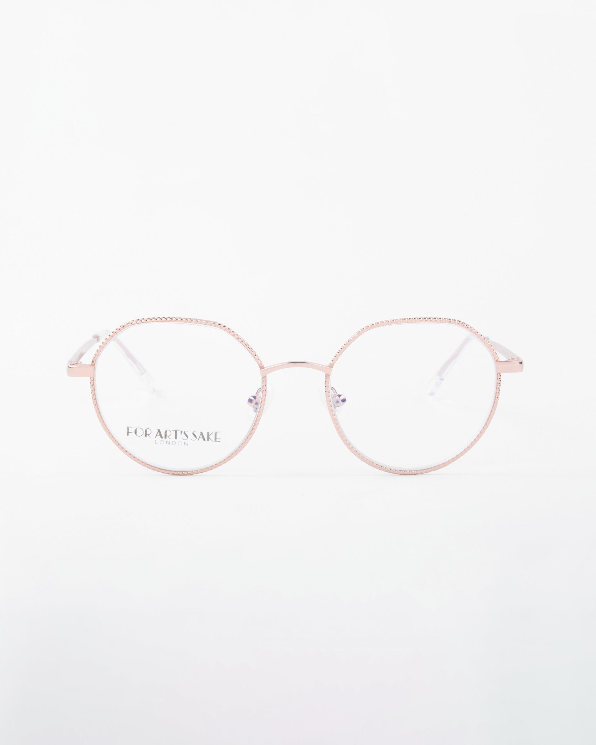 A pair of round eyeglasses with thin, light pink metal frames is displayed against a plain white background. The lenses feature a Blue Light Filter, and the brand name &quot;For Art&#39;s Sake®&quot; is visible on the left lens. The slender temples match the frame color perfectly. These eyeglasses are named Hope.