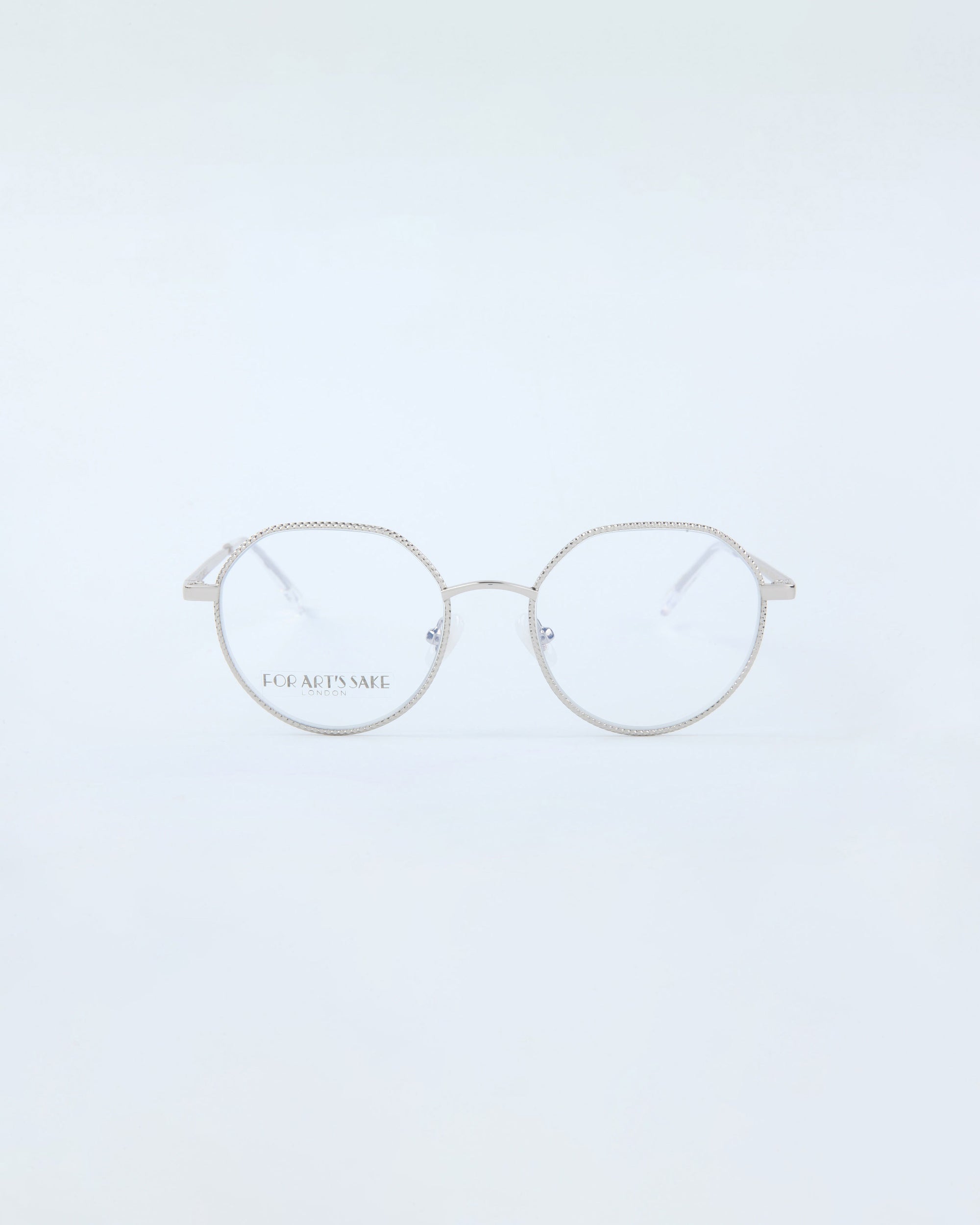 The Hope Silver eyeglasses by For Art's Sake® are delicate, round-framed unisex glasses with a lightweight build and thin metallic rims, set on a plain white background. They boost comfort and style with subtle hinges and nose pads.