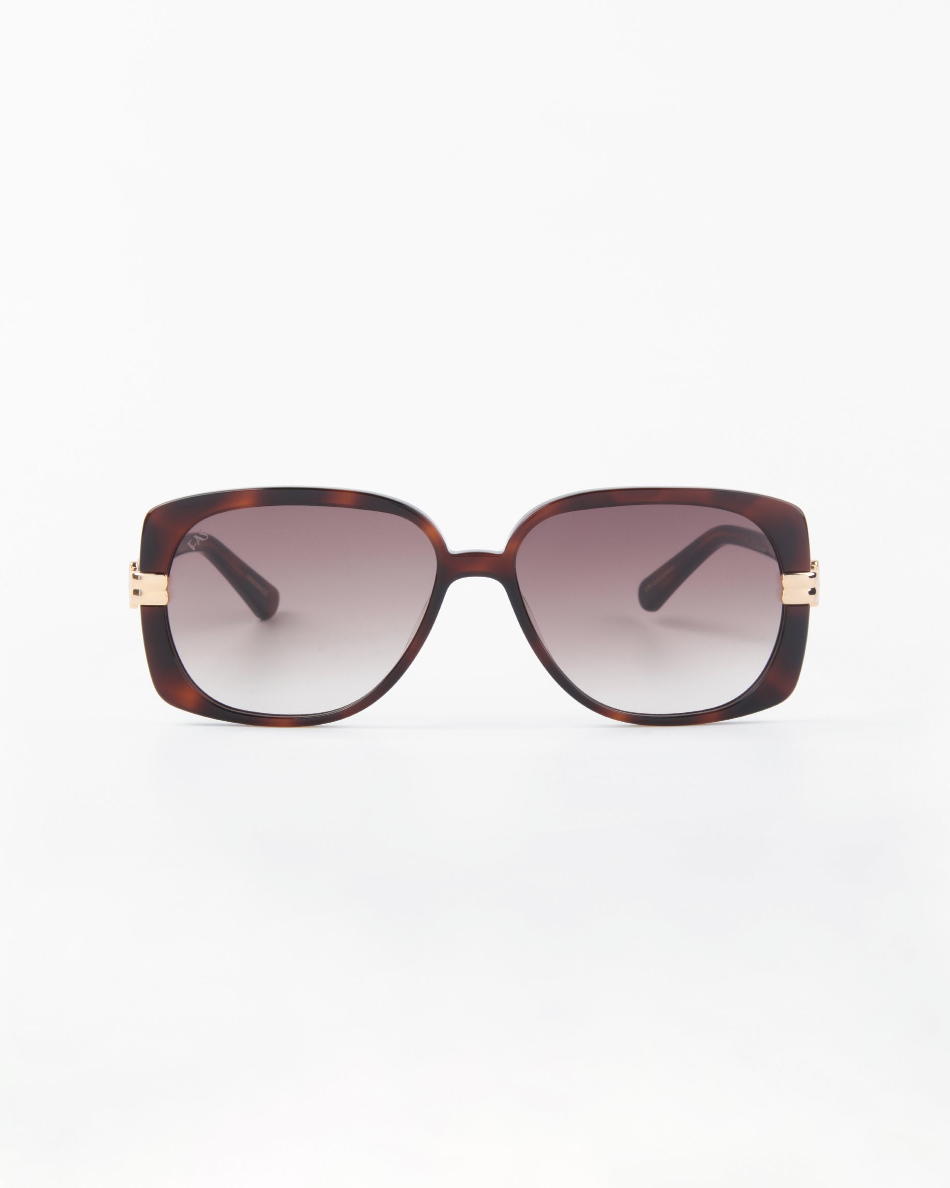 A pair of stylish, oversized Icon sunglasses with rectangular frames in a dark tortoiseshell pattern from For Art's Sake®. Handmade with shatter-resistant nylon lenses, they feature gradient lenses and small gold accents on the temples. The UVA & UVB-protected sunglasses are set against a plain white background.