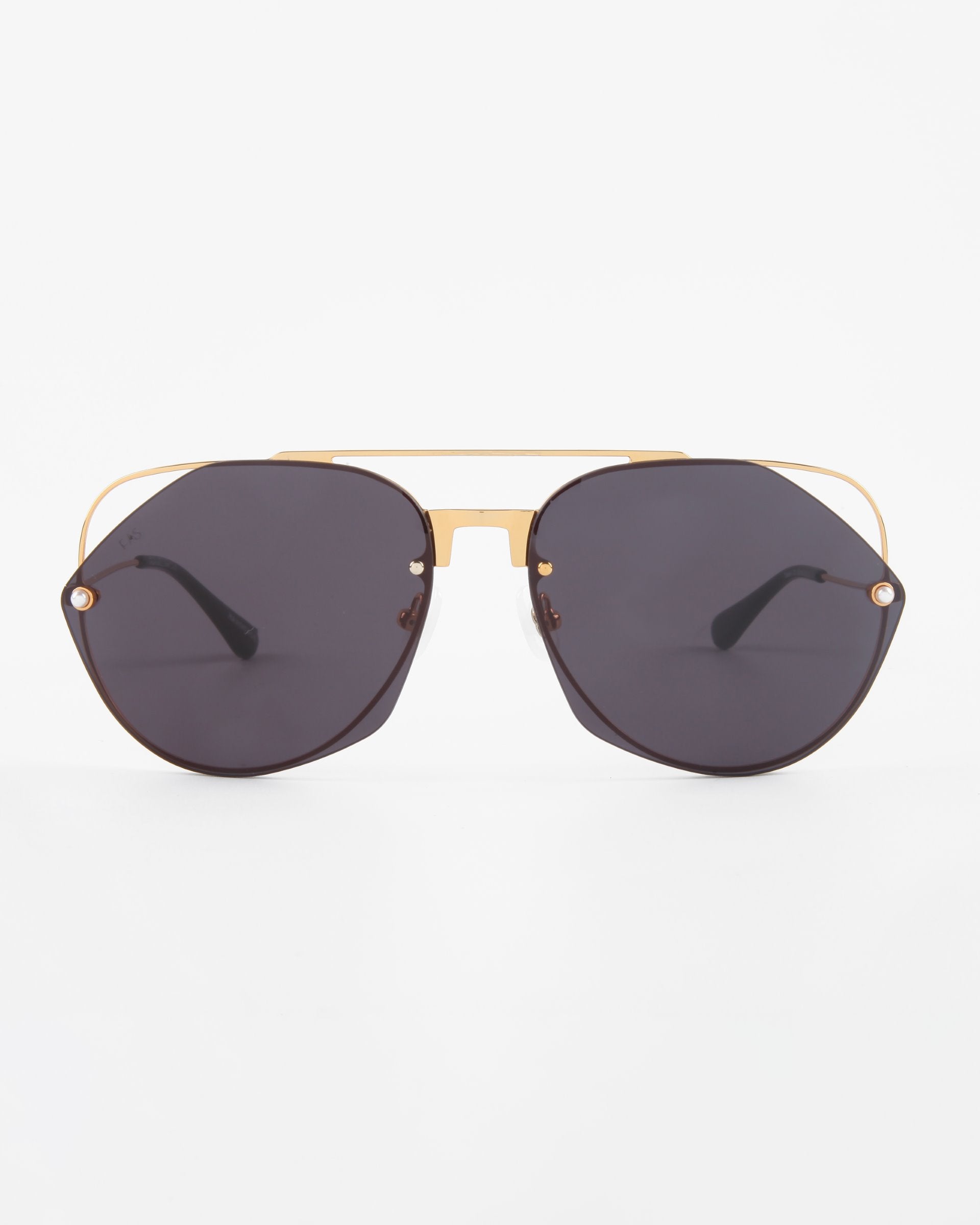 A pair of stylish For Art&#39;s Sake® Casino sunglasses with dark, hexagonal nylon lenses and a gold metal frame. The sunglasses also feature a double bridge design and black temple tips, offering top-notch UV protection. The background is plain white.