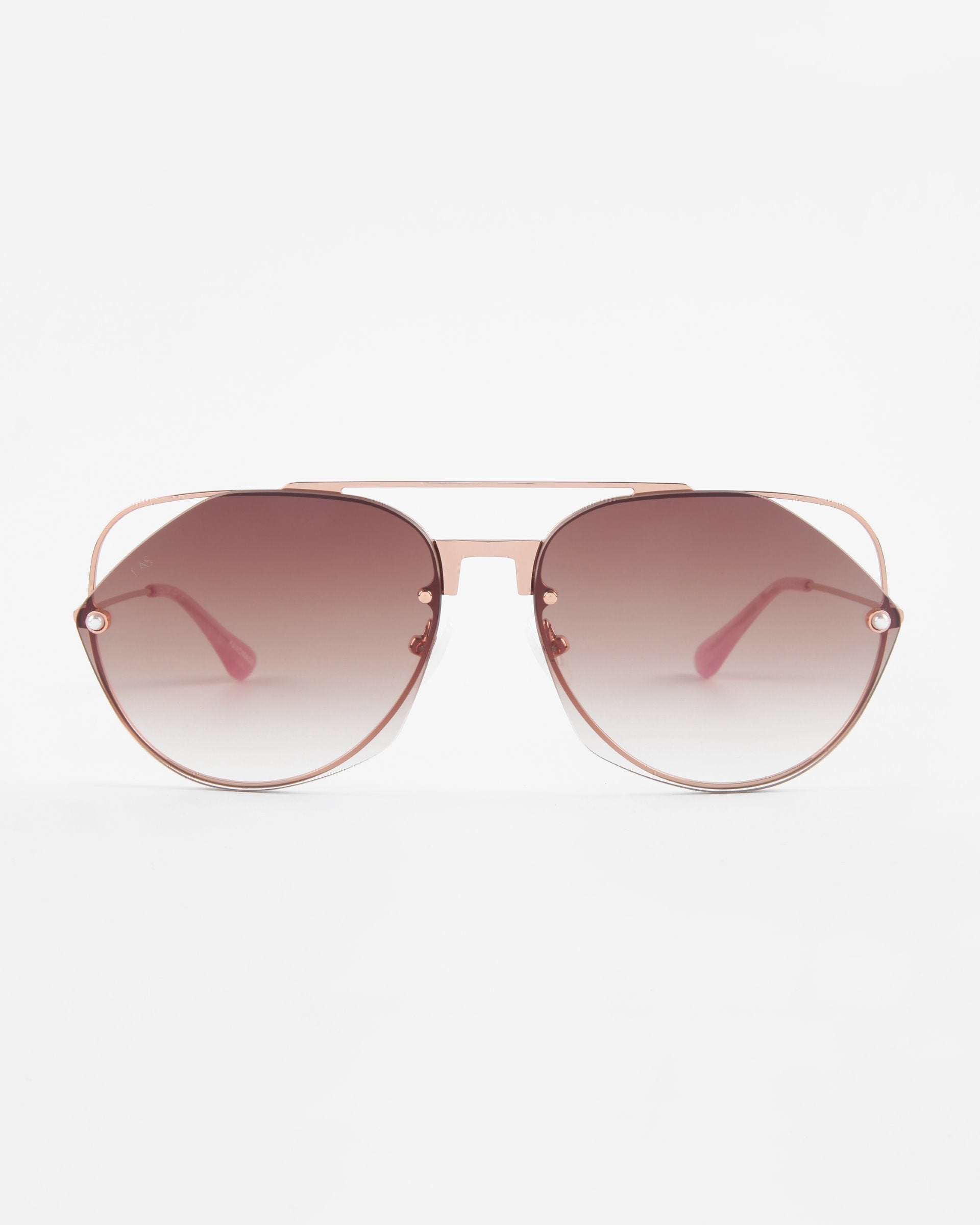 A pair of stylish Casino aviator sunglasses by For Art&#39;s Sake® with a pink tinted gradient, gold metal frames, and nylon lenses offering UV protection. The sunglasses are positioned facing forward against a plain white background.