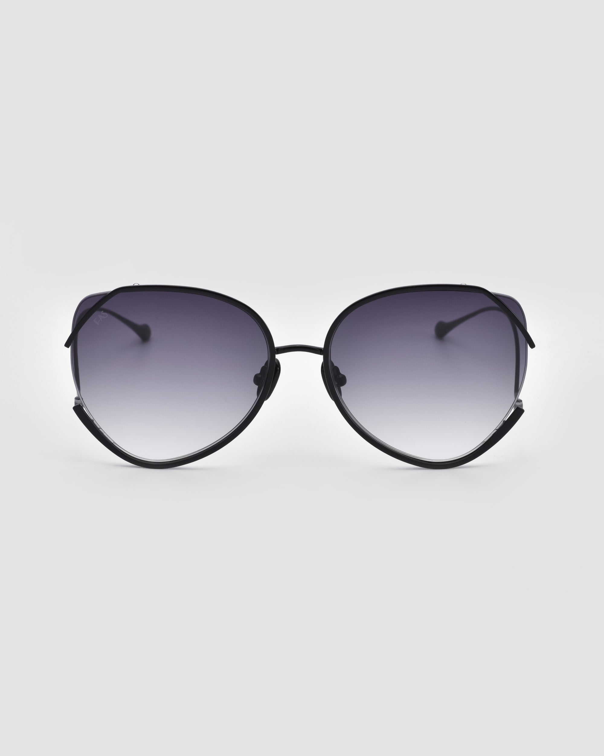 A pair of stylish, oversized Wonderland sunglasses from For Art's Sake®, featuring dark gradient lenses and a thin black frame, are centered against a plain white background. The ultralightweight shatter-resistant nylon lenses ensure durability, and the arms of the Wonderland sunglasses slightly curve at the ends.