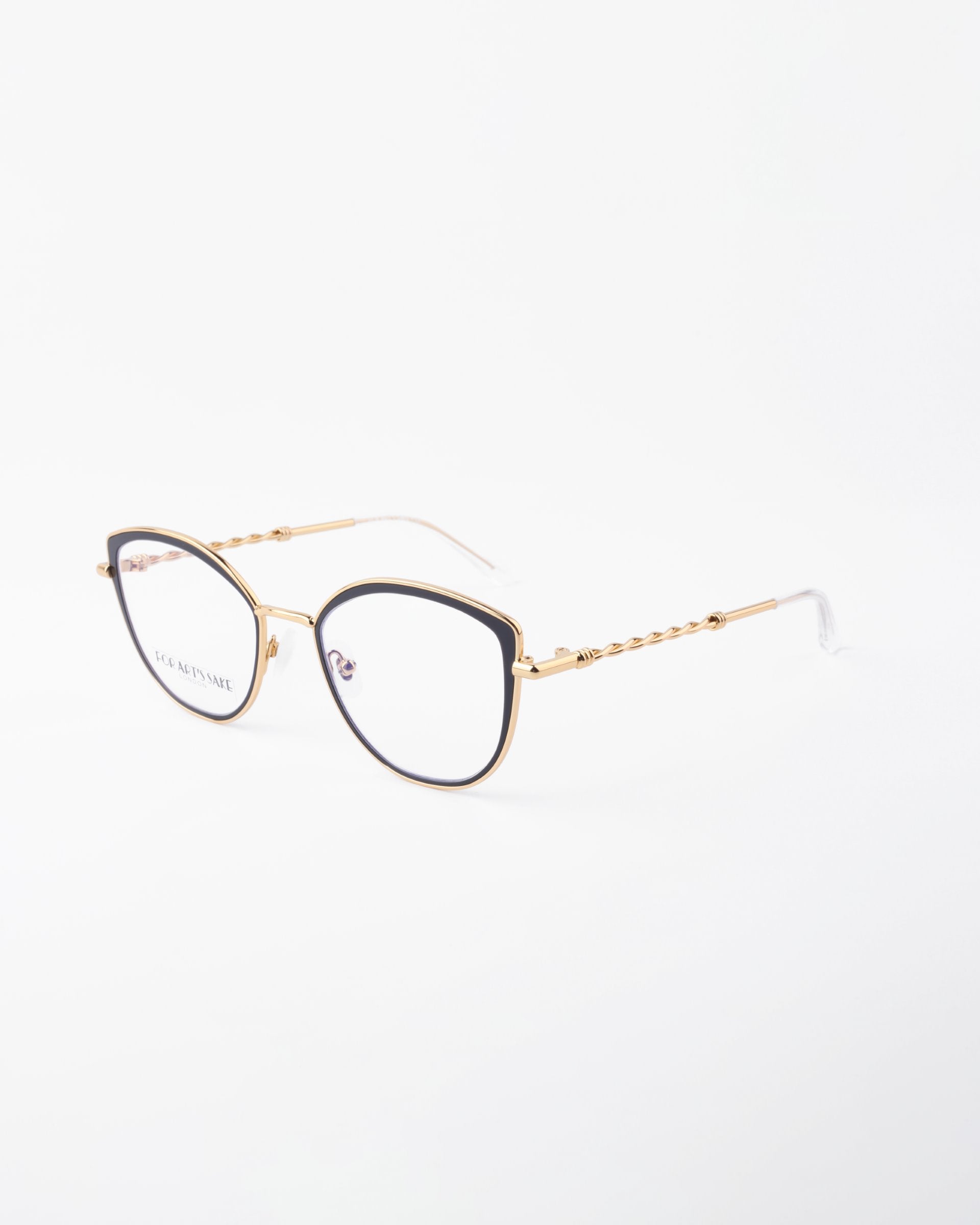 A pair of stylish eyeglasses with thin 18-karat gold-plated frames, black detailing around the lenses, and a twisted design on the earpieces. Featuring a Blue Light Filter, these For Art's Sake® Julie glasses are displayed on a white background and angled slightly to the left.