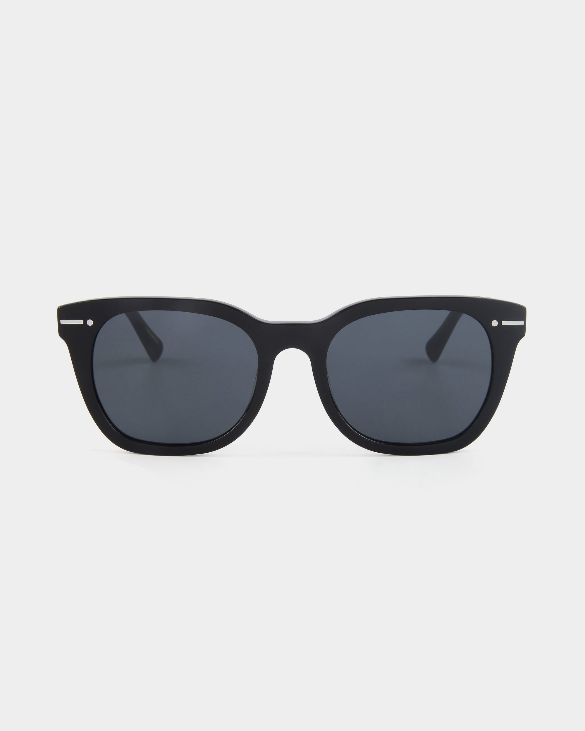 A pair of black rectangular For Art&#39;s Sake® Jacuzzi sunglasses with dark tinted Nylon lenses is displayed against a plain white background. The frame, made of Mazzucchelli acetate, is matte black with subtle silver accents near the hinges. These sunglasses offer classic minimalist style and complete UVA &amp; UVB protection.
