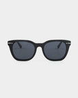 A pair of black rectangular For Art's Sake® Jacuzzi sunglasses with dark tinted Nylon lenses is displayed against a plain white background. The frame, made of Mazzucchelli acetate, is matte black with subtle silver accents near the hinges. These sunglasses offer classic minimalist style and complete UVA & UVB protection.
