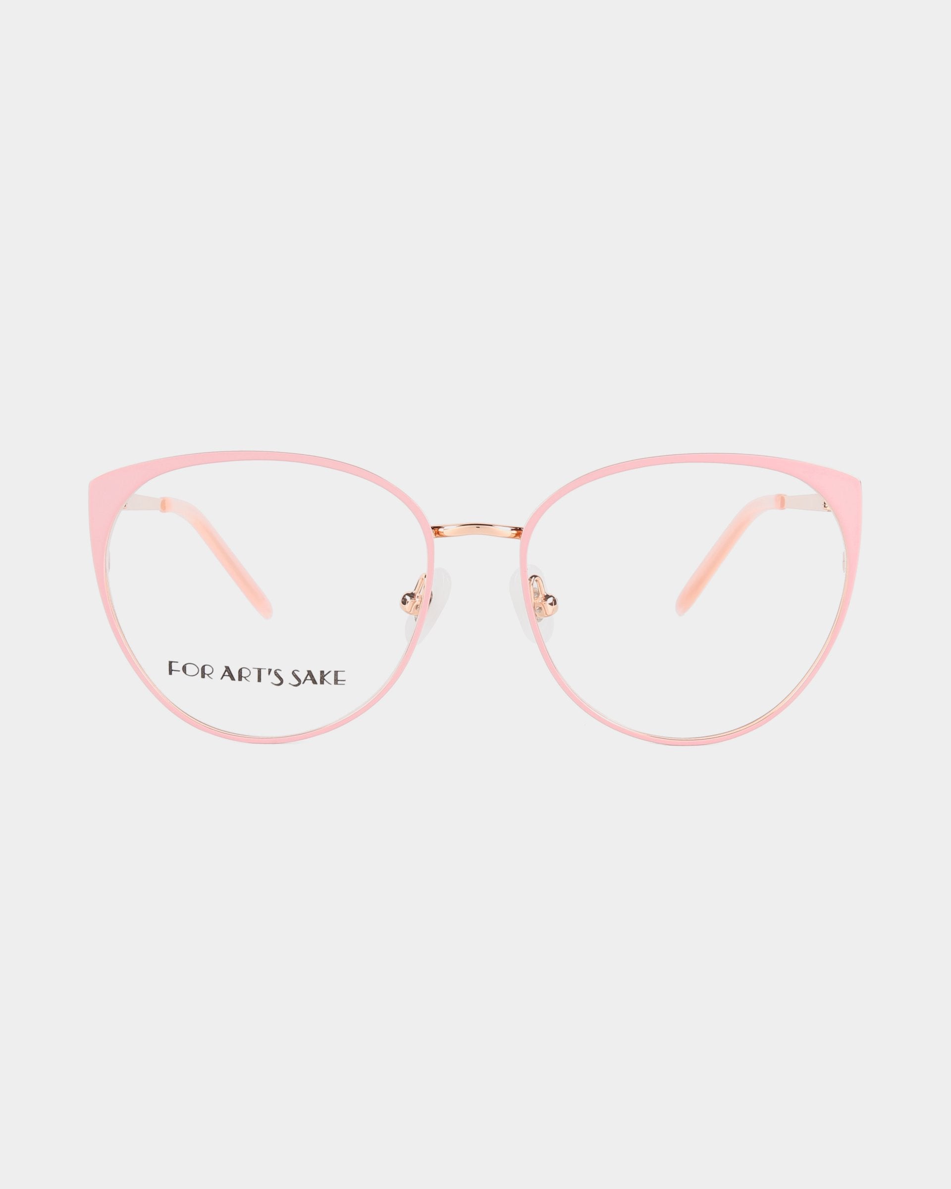 A pair of pink cat-eye glasses with clear lenses and a thin gold nose bridge featuring 18-karat gold plating. The inner arms are light pink, and the left lens has &quot;For Art&#39;s Sake®&quot; written in black text. The Kaia glasses, which also offer a blue light filter, are set against a plain white background.