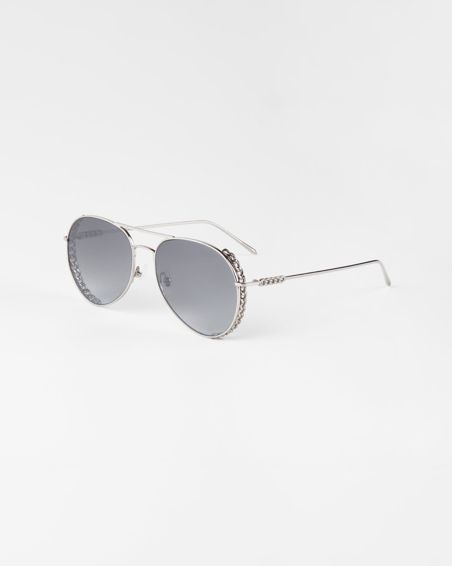 A pair of stylish Links aviator sunglasses by For Art&#39;s Sake® with gold-plated stainless steel frames and gradient nylon lenses is displayed on a plain white background. The Links sunglasses have thin metal arms and intricate detailing on the bridge and temples.