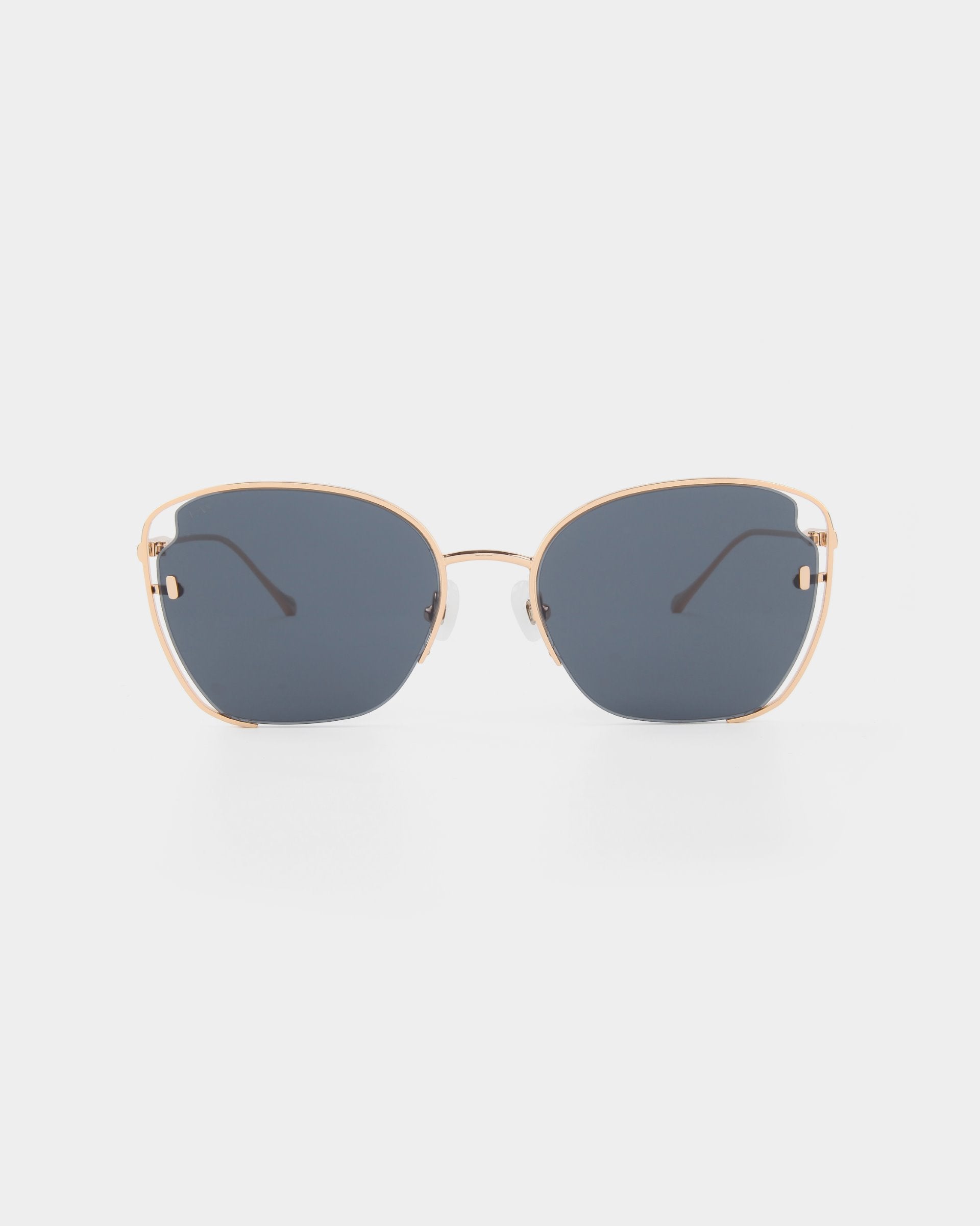 A pair of For Art's Sake® Eden sunglasses with 18-karat gold plated frames and dark blue-tinted, UVA & UVB-protected lenses viewed from the front against a white background. The frames have a slight curve at the top and thin temples with black tips.