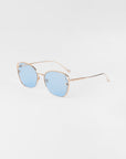 A pair of Eden sunglasses by For Art's Sake® with thin, 18-karat gold-plated frames and light blue-tinted square lenses is displayed against a plain white background. The glasses have subtly curved arms and a minimalist design, exuding a modern and sophisticated appearance, while being UVA & UVB-protected.