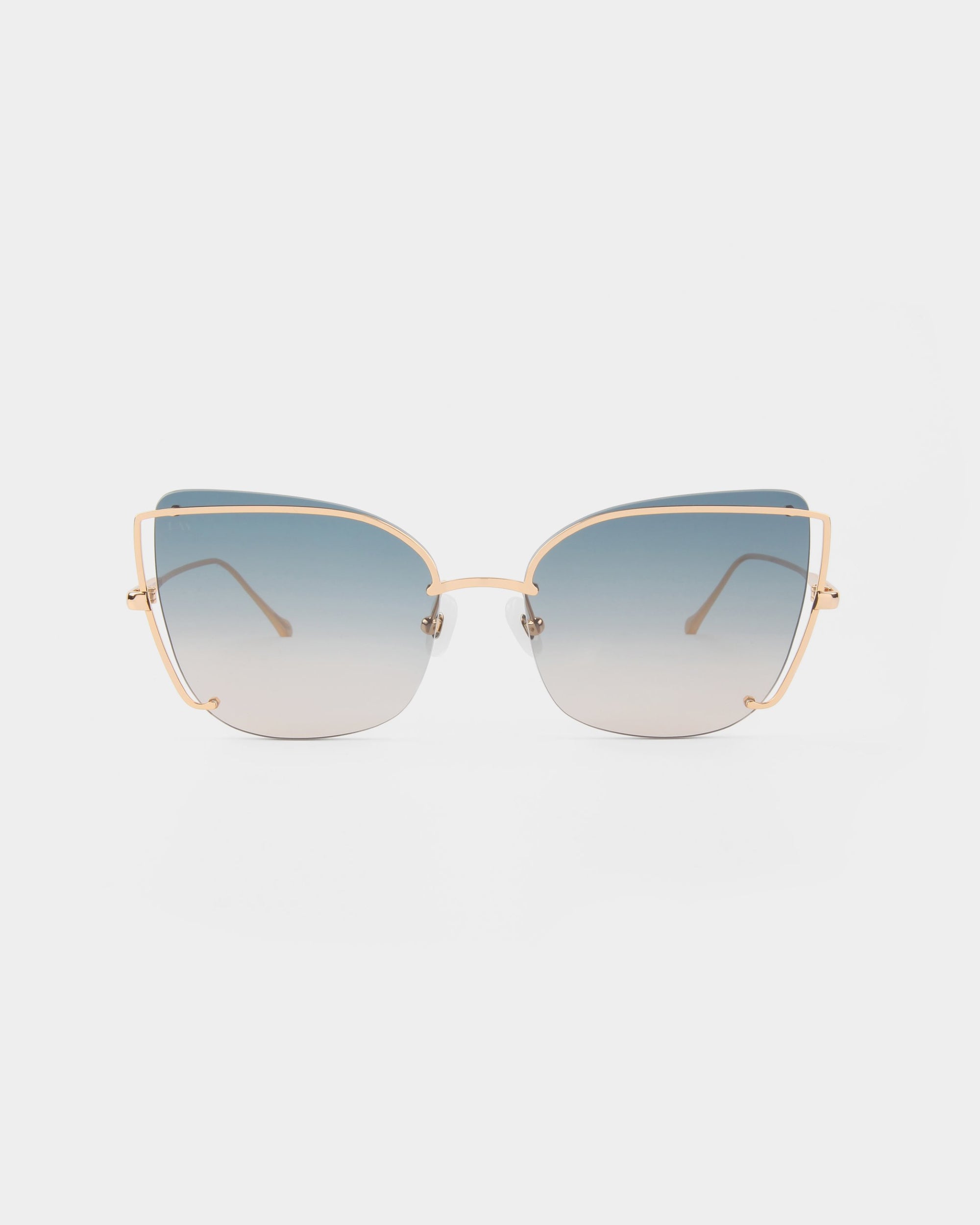 A pair of Meow cat-eye sunglasses by For Art&#39;s Sake® features gold-colored metal frames and large, gradient lenses that transition from dark blue at the top to a lighter hue at the bottom, creating a stylish statement. The background is plain white.