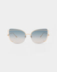 A pair of Meow cat-eye sunglasses by For Art's Sake® features gold-colored metal frames and large, gradient lenses that transition from dark blue at the top to a lighter hue at the bottom, creating a stylish statement. The background is plain white.