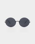 A pair of round, dark-tinted For Art's Sake® Oceana sunglasses with thin stainless steel frames is centered against a white background. The minimalist design features simple, straight temples and nose pads, giving them a sleek and modern look while offering UVA & UVB protection.