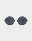 A pair of round, dark-tinted For Art's Sake® Oceana sunglasses with thin stainless steel frames is centered against a white background. The minimalist design features simple, straight temples and nose pads, giving them a sleek and modern look while offering UVA & UVB protection.