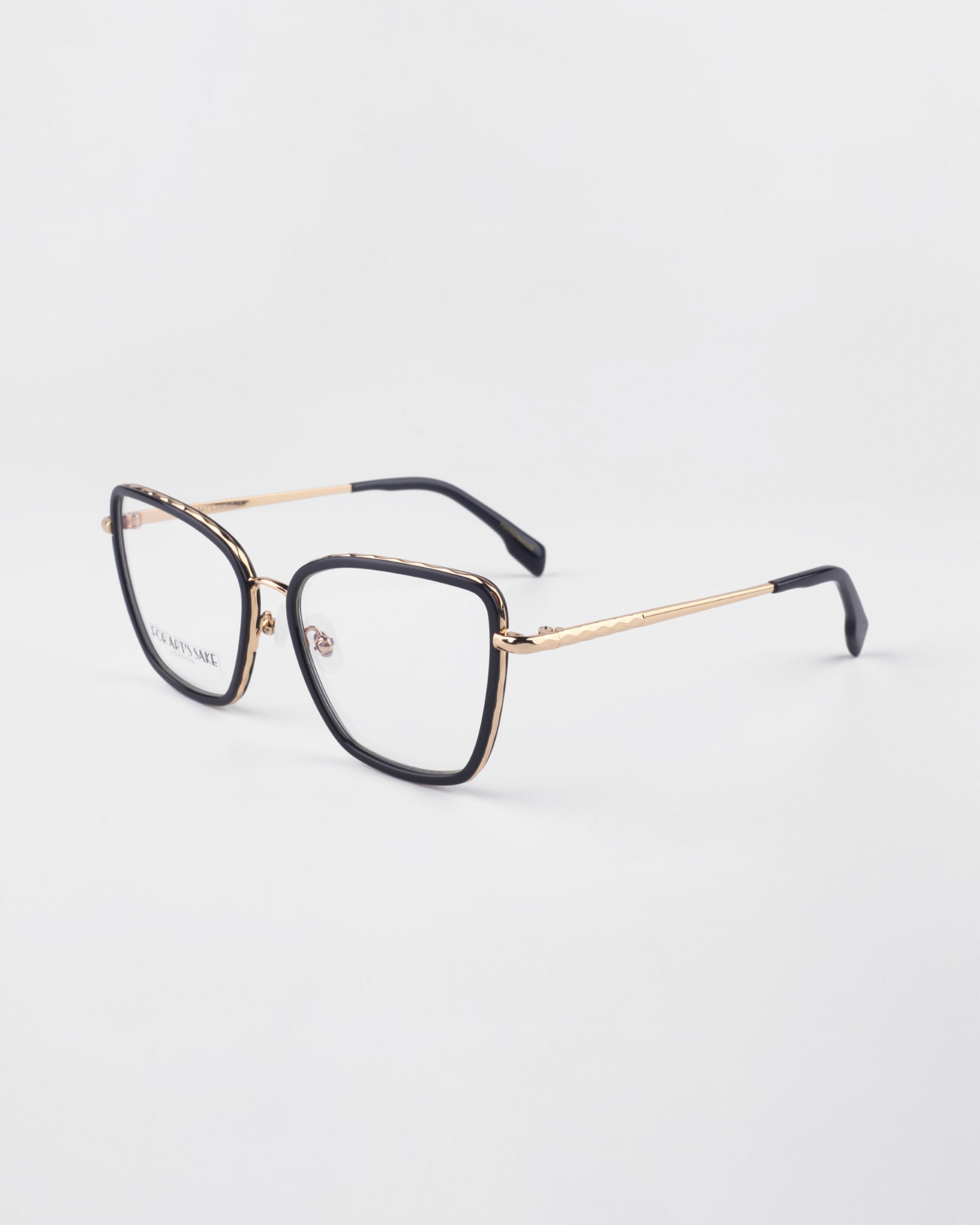 A pair of Lace eyeglasses by For Art&#39;s Sake® with a sleek black frame and 18-karat gold-plated arms. The glasses, featuring prescription lenses, rest on a white background, angled to show both the front and side views of the stylish frame.