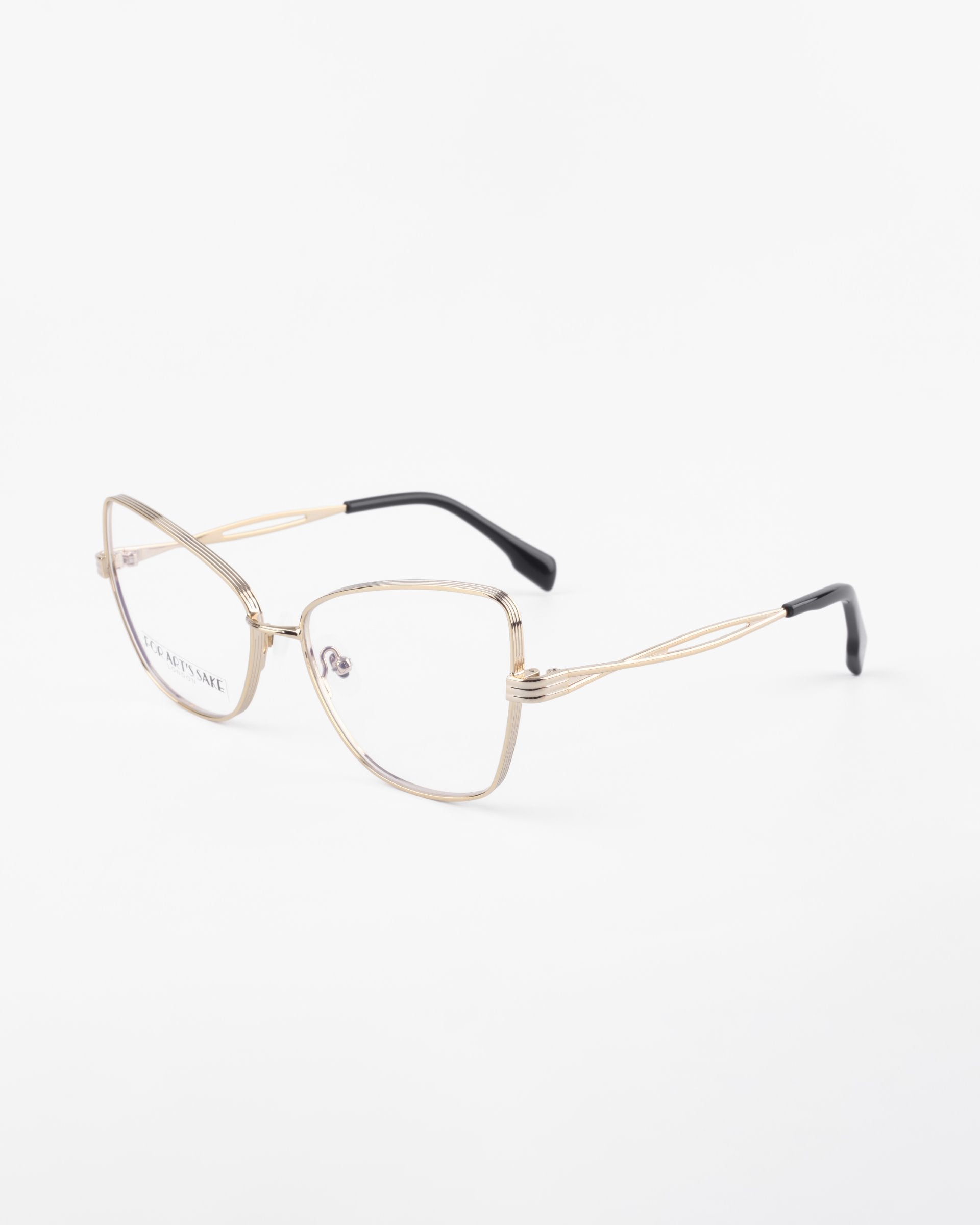A pair of For Art's Sake® Lady eyeglasses with gold wire frames and a cat-eye silhouette. The temples feature a delicate, openwork design and have black plastic tips for comfort. These stylish glasses can be fitted with prescription lenses or an optional blue light filter. The background is a plain white surface.