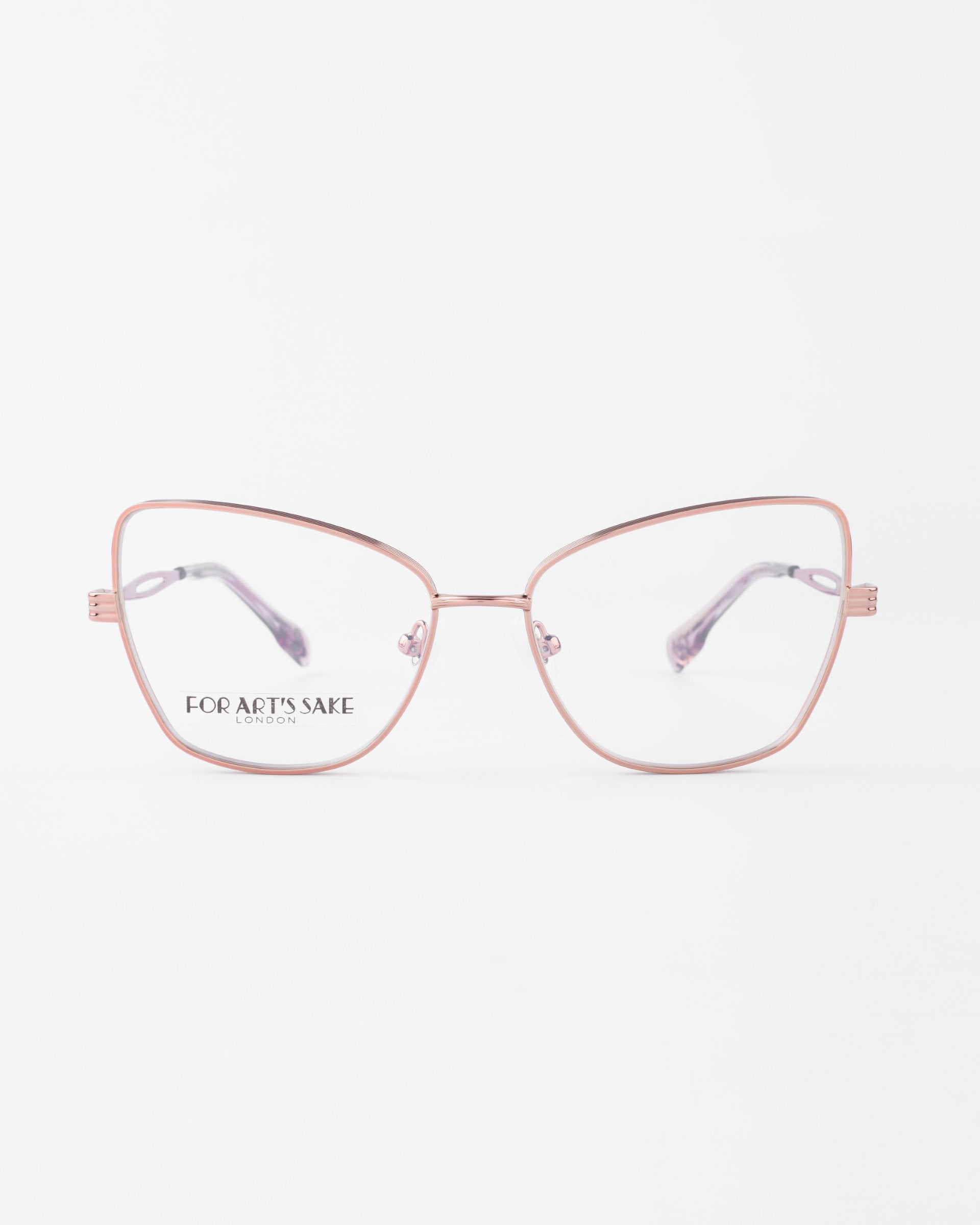 A pair of Lady by For Art&#39;s Sake® eyeglasses with rose gold metal frames and clear lenses. The frame features a modern, geometric cat-eye silhouette with subtle design details on the temples, set against a plain white background.