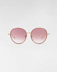 A pair of round Lemon sunglasses from For Art's Sake® with thin, metallic golden frames and pink-tinted gradient lenses, complemented by jadestone nose pads and 18-karat gold plating, set against a plain, light gray background.