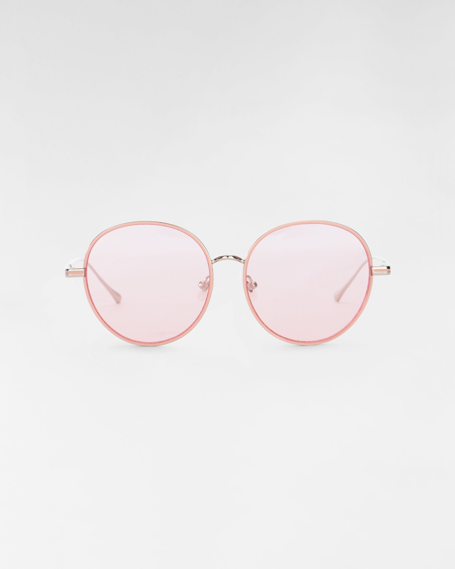 A pair of round Lemon sunglasses by For Art's Sake®, featuring thin, light pink frames and matching light pink-tinted lenses, set against a plain white background. The minimalist and modern design includes jadestone nose pads.