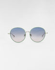 A pair of round For Art's Sake® Lemon sunglasses with green frames and blue gradient lenses is displayed against a plain white background. The temples and nose bridge are metallic, featuring 18-karat gold plating, and the earpieces extend outwards in a straight line.