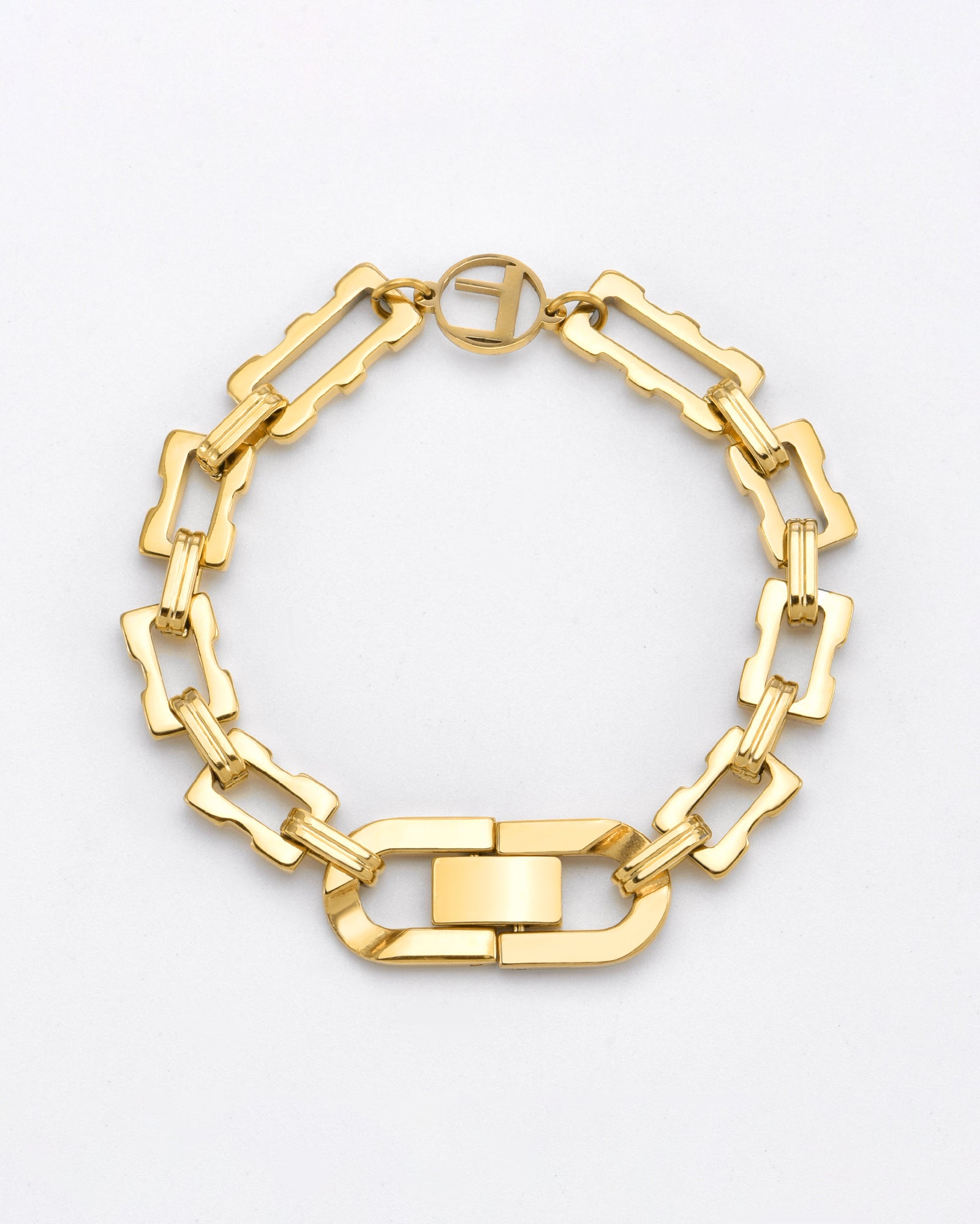 A 24k gold-plated bracelet with an XL link chain design. The Links Bracelet Gold by For Art's Sake® features interconnected rectangular links and a larger central clasp with a circular detail near the clasp. Hypoallergenic, the overall design is elegant and modern, set against a plain white background.
