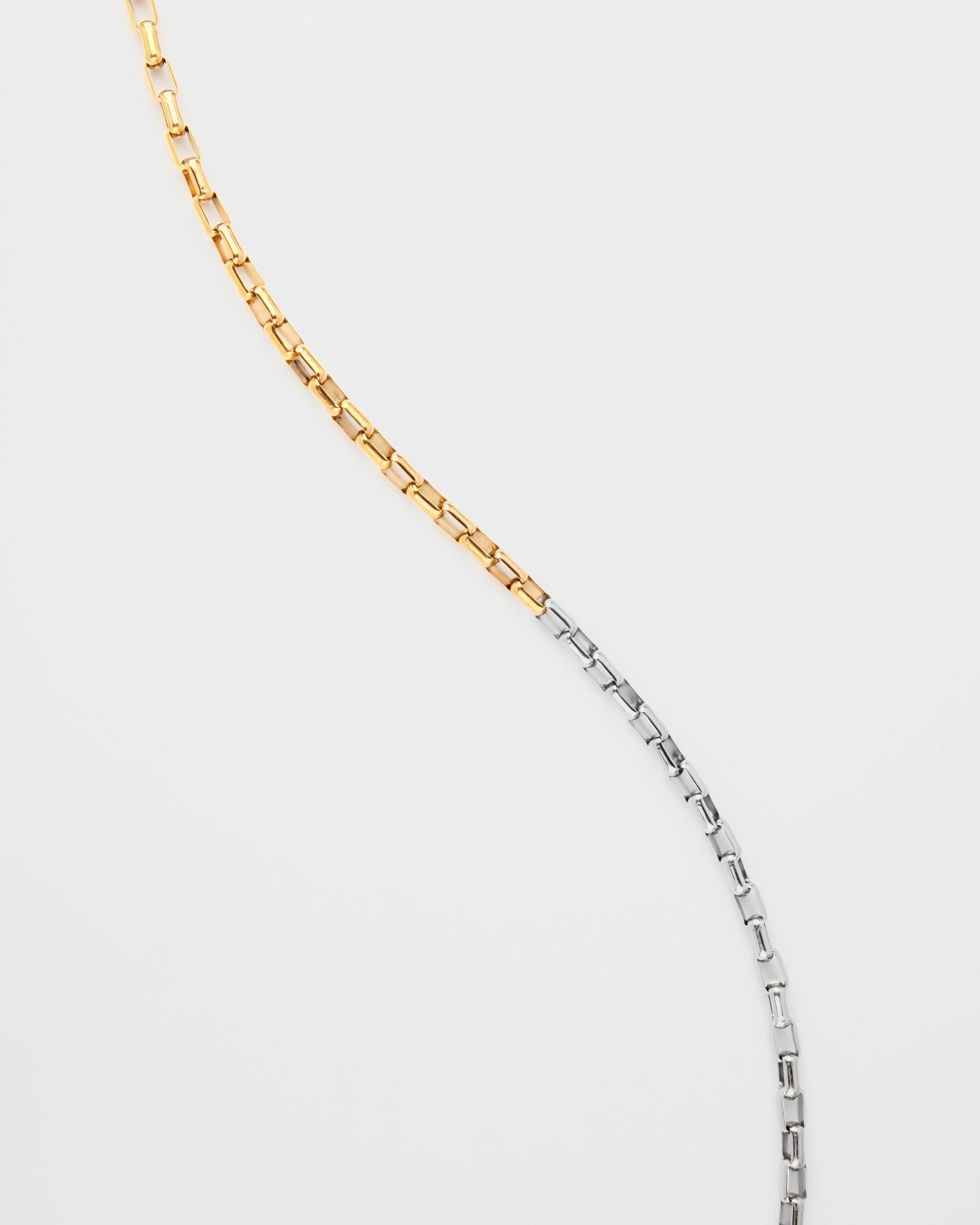 A For Art&#39;s Sake® Luna Glasses Chain, placed against a plain white background. The upper half of the chain is gold-toned, while the lower half is silver-toned, forming an elegant and continuous curve from top to bottom.