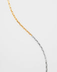 A For Art's Sake® Luna Glasses Chain, placed against a plain white background. The upper half of the chain is gold-toned, while the lower half is silver-toned, forming an elegant and continuous curve from top to bottom.