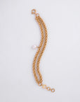 The For Art's Sake® Miller Bracelet features two strands intertwined together. One strand has a single freshwater pearl charm, adding a touch of elegance. The 18kt gold-plated bracelet boasts an adjustable loop segment for sizing and a clasp for fastening, all set against a plain white background.