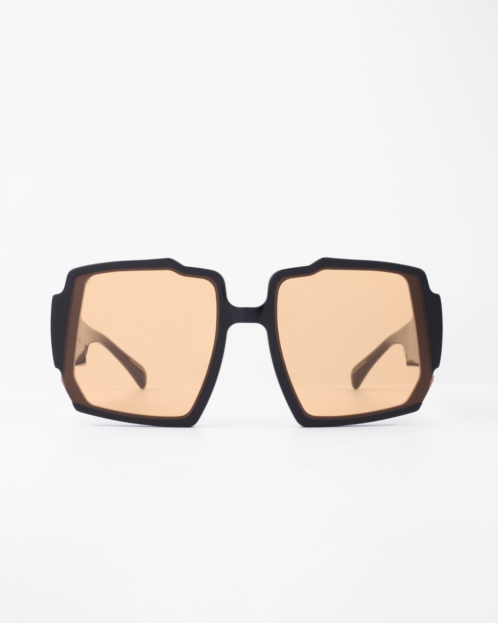 A pair of stylish black square-framed Moritz by For Art's Sake® with light brown tinted, UV-protected lenses. Featuring a chunky acetate frame and subtle gold-plated inlay, the Moritz sunglasses are displayed against a plain white background, giving a clear view of their modern and sleek design.