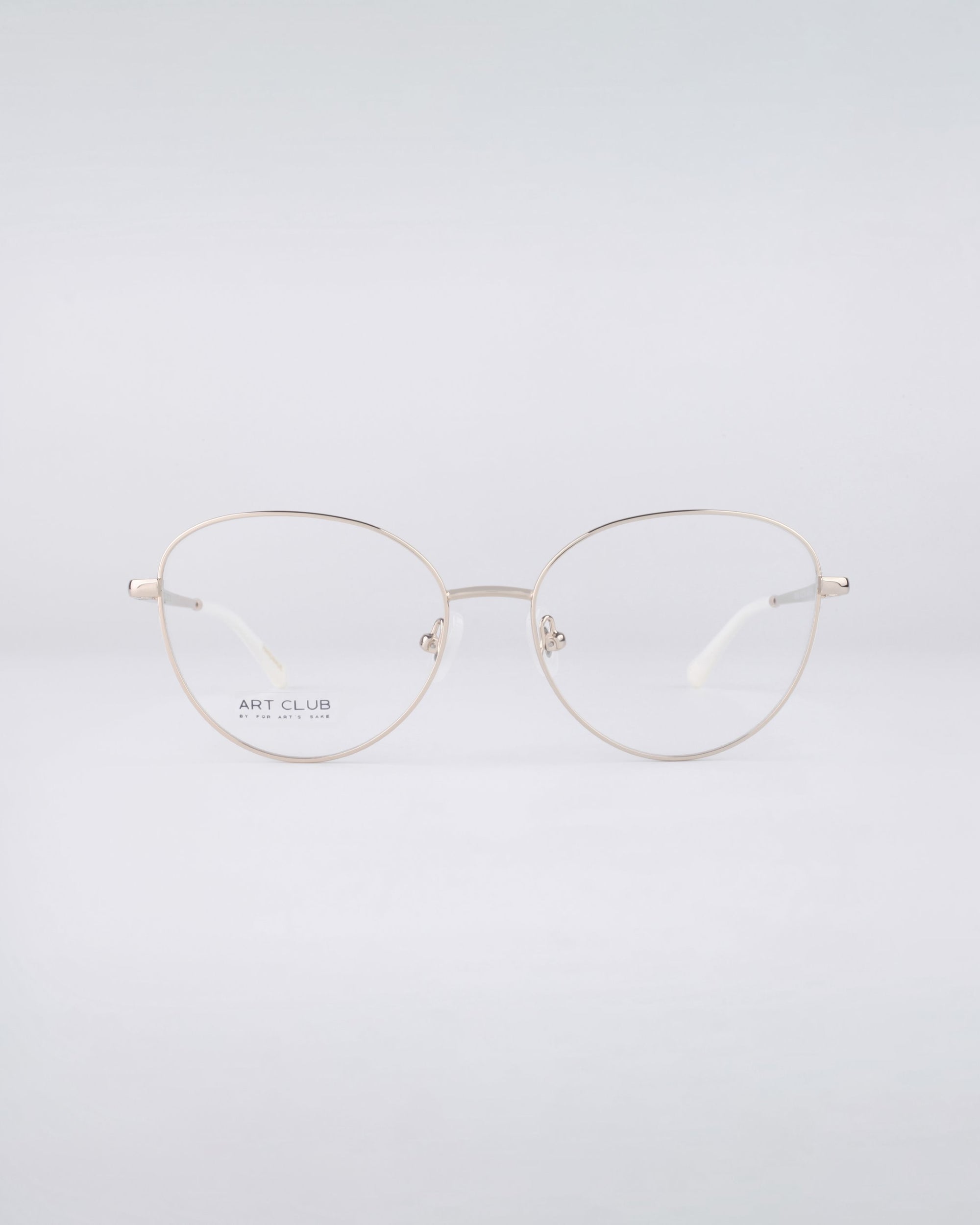 A pair of thin, metal-framed Millie glasses from For Art's Sake® featuring clear lenses and a stainless steel core stands elegantly against a plain white background.