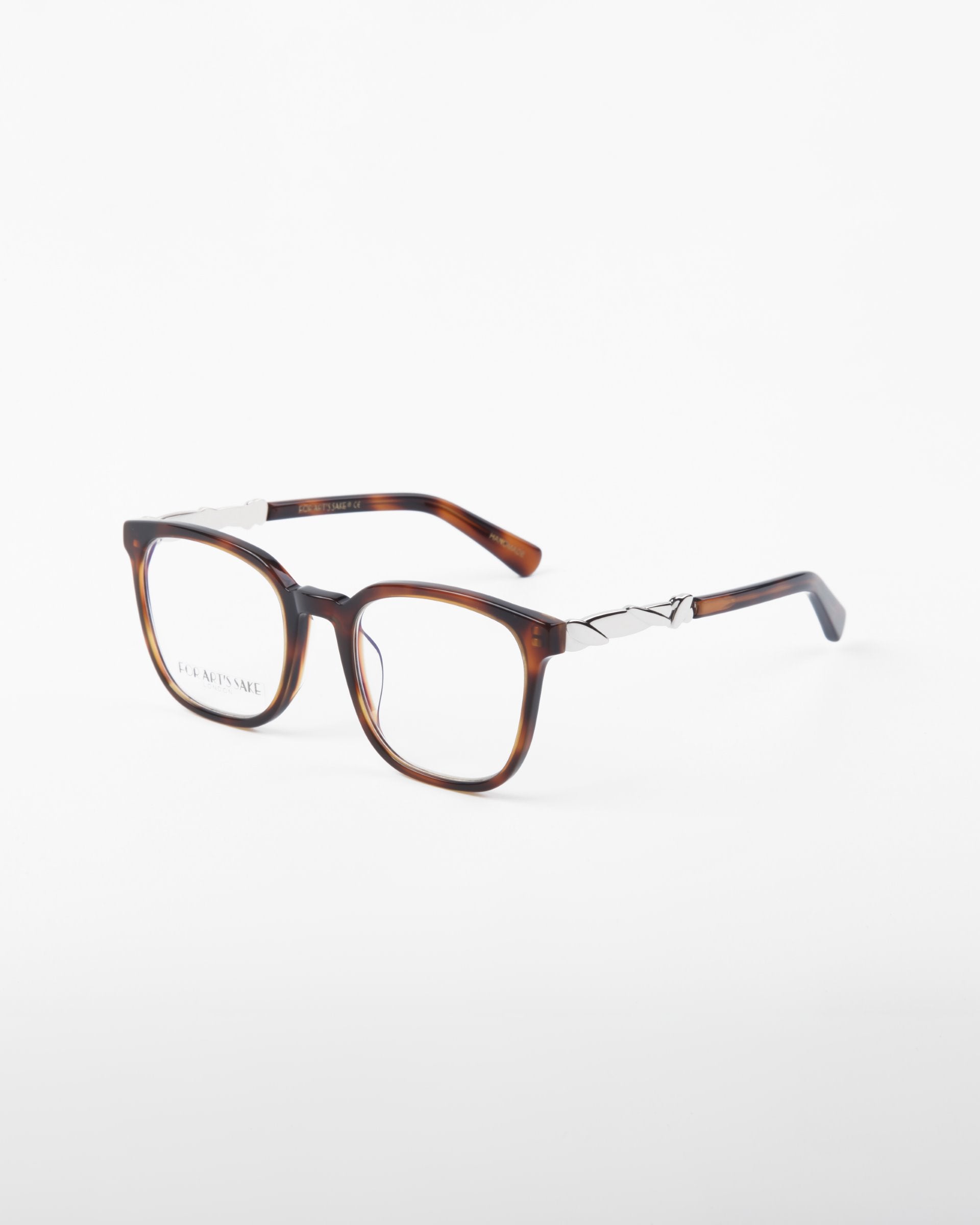 A pair of For Art&#39;s Sake® Molten rectangular eyeglasses with tortoiseshell frames made from plant-based acetate and silver metal accents on the temples, set against a plain white background. The lenses are clear, suitable for prescription eyewear or fashion wear, and potentially feature a blue light filter.