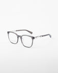 A pair of gray square eyeglasses made from plant-based acetate with a subtle transparent frame and silver accents on the temples. These stylish Molten prescription eyewear glasses by For Art's Sake® are displayed against a plain white background.