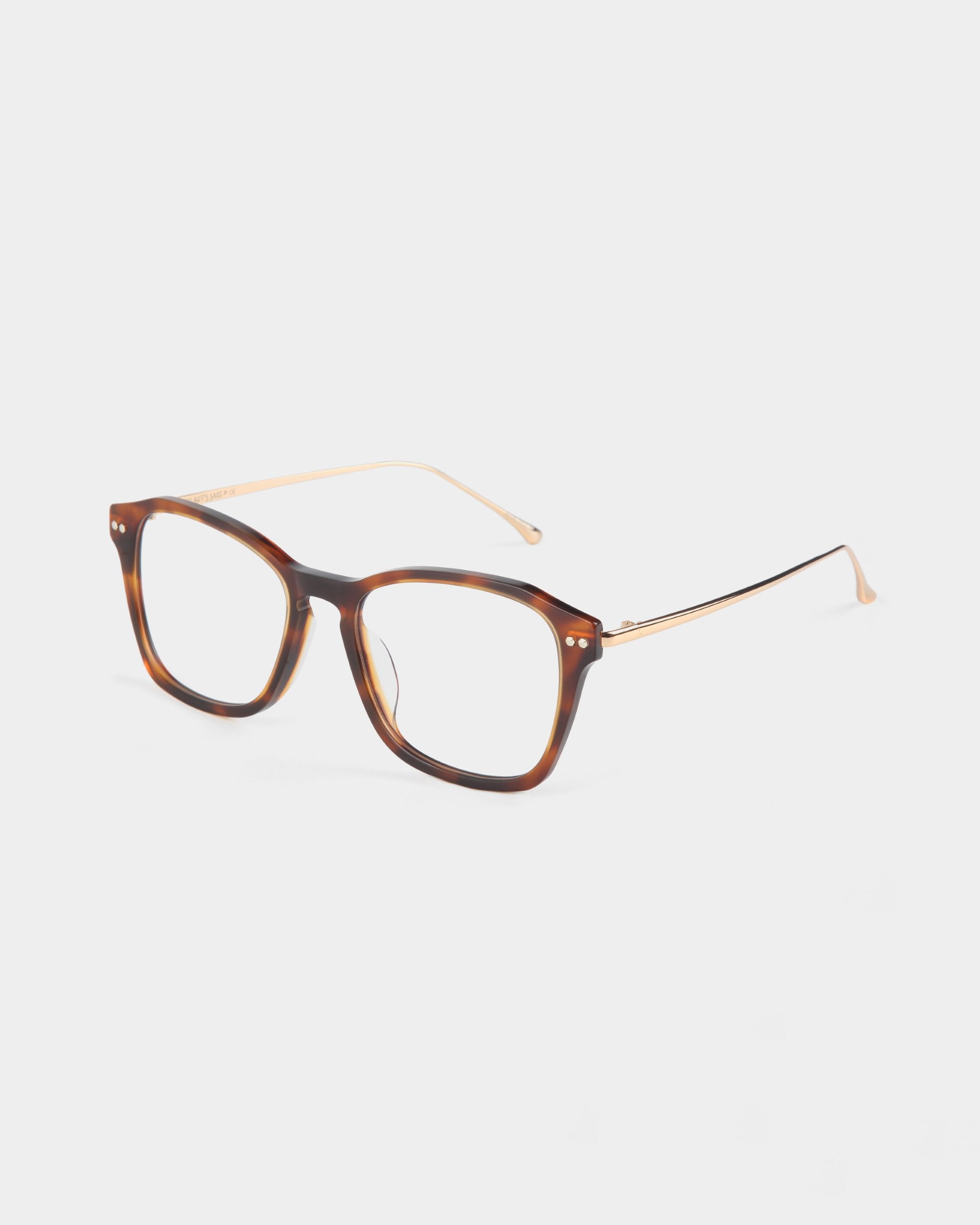 A pair of eyeglasses featuring square, tortoiseshell frames and thin gold temples. The style is modern with a blend of classic and contemporary design elements. They come with adjustable nose pads for comfort and an optional blue light filter. The background is plain and light-colored. This stylish accessory is the Morris by For Art's Sake®.