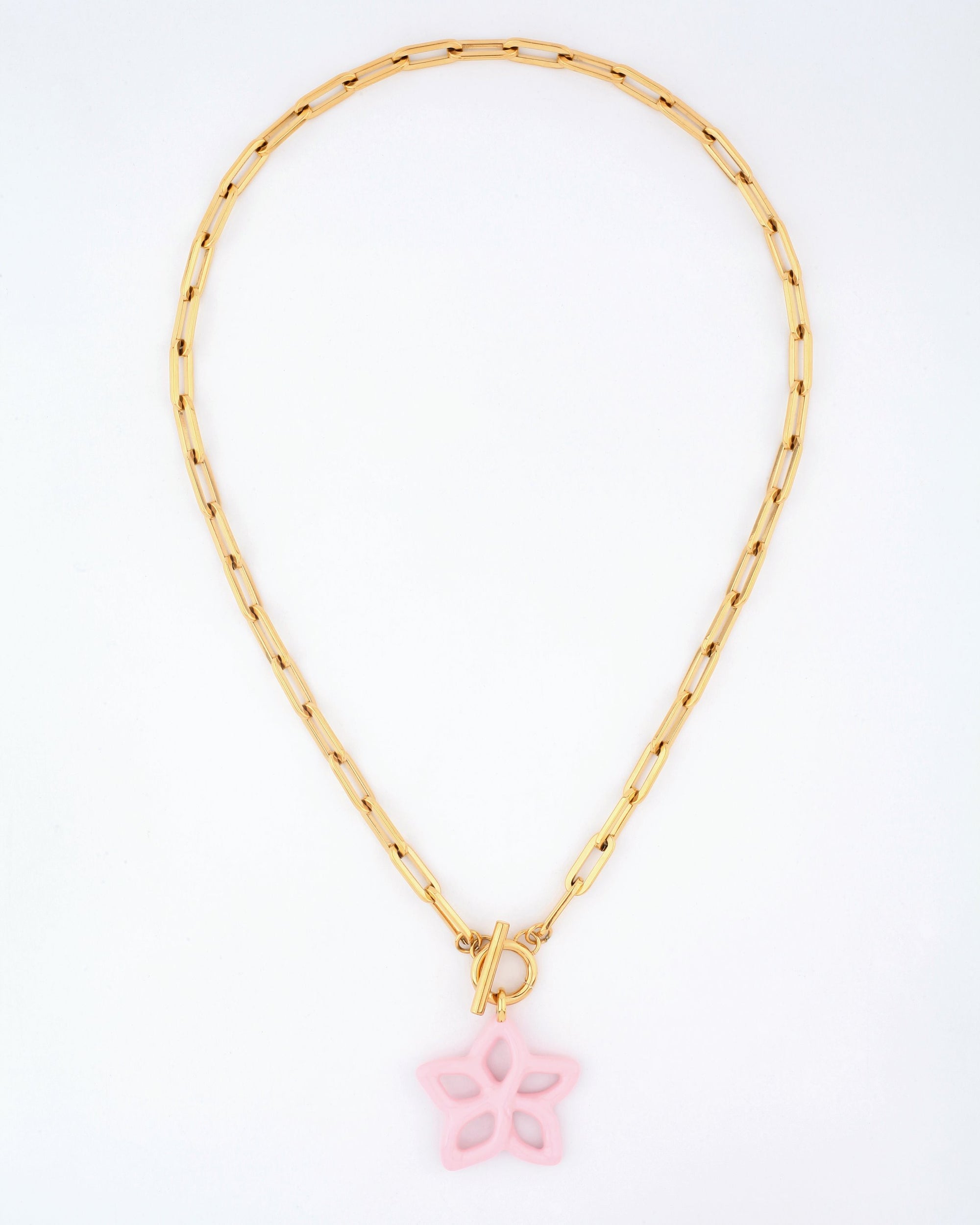 The Plumeria Necklace by For Art&#39;s Sake® features a gold chain with elongated rectangular links and a 49cm length. This elegant piece includes a toggle clasp and is adorned with a pastel pink butterfly-shaped pendant, embodying minimalistic sophistication with its striking contrast between the gold chain and the delicate charm.