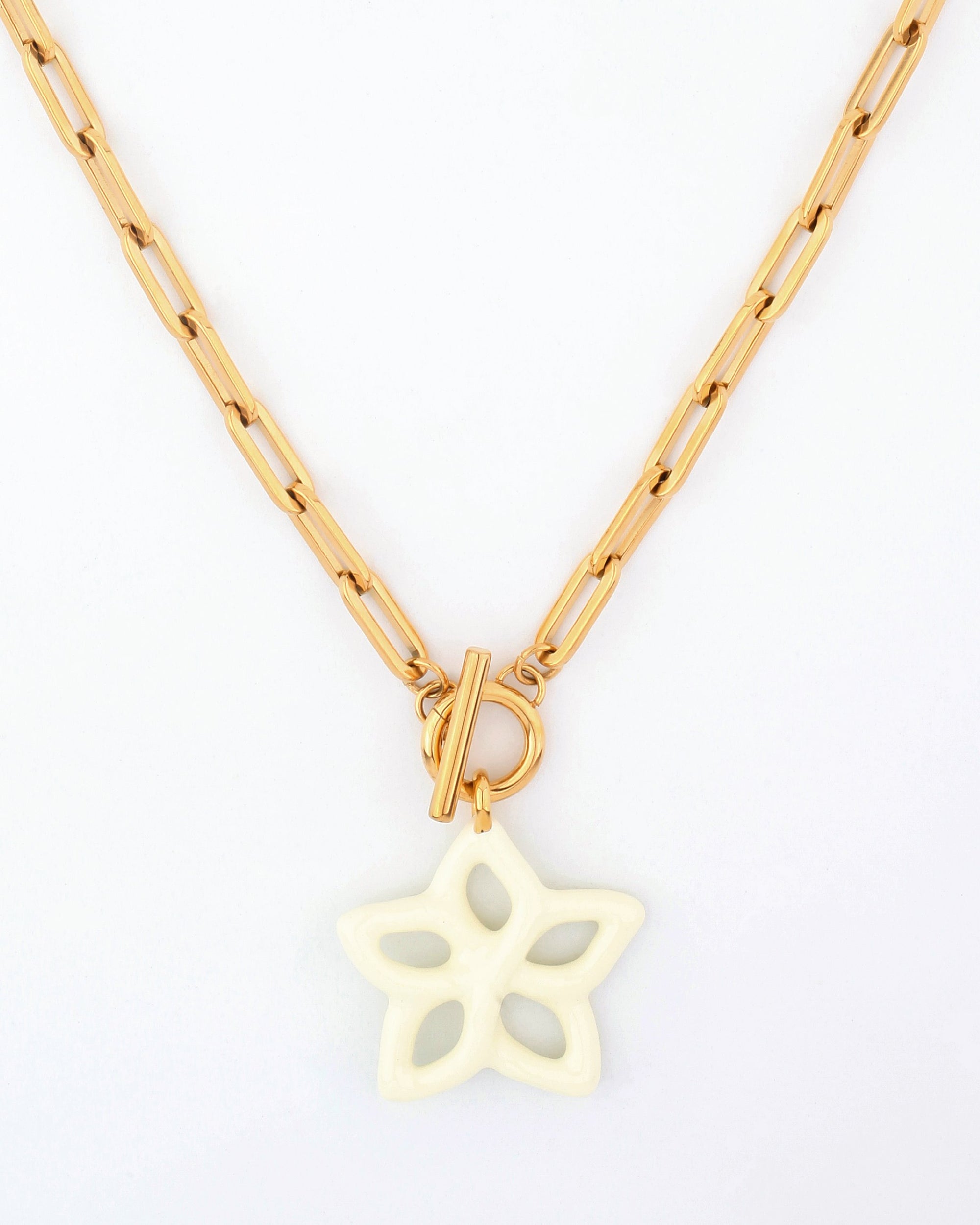 The Plumeria Necklace by For Art&#39;s Sake® is a gold chain necklace featuring an intricate design with elongated links. Measuring 49cm in length, it has a toggle clasp and a white star-shaped pendant with five cut-out sections, giving it a delicate and unique appearance against a white background.