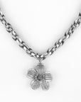 Introducing the Blossom Necklace by For Art's Sake®: a stunning silver chain necklace featuring a flower-shaped pendant. The five-petal pendant boasts intricate texture and a subtle shine, hanging gracefully at the center of the 46cm chain. This exquisite piece is designed to perfectly complement any outfit.