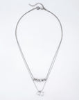 Introducing the Nora Necklace by For Art's Sake®: A stunning silver double-chain piece adorned with a cubic zirconia pendant. The upper chain is elegantly accented with small silver beads, while the lower chain boasts a striking square-shaped crystal charm. This adjustable necklace also features an extension chain, allowing you to effortlessly customize the inner length to your preference.