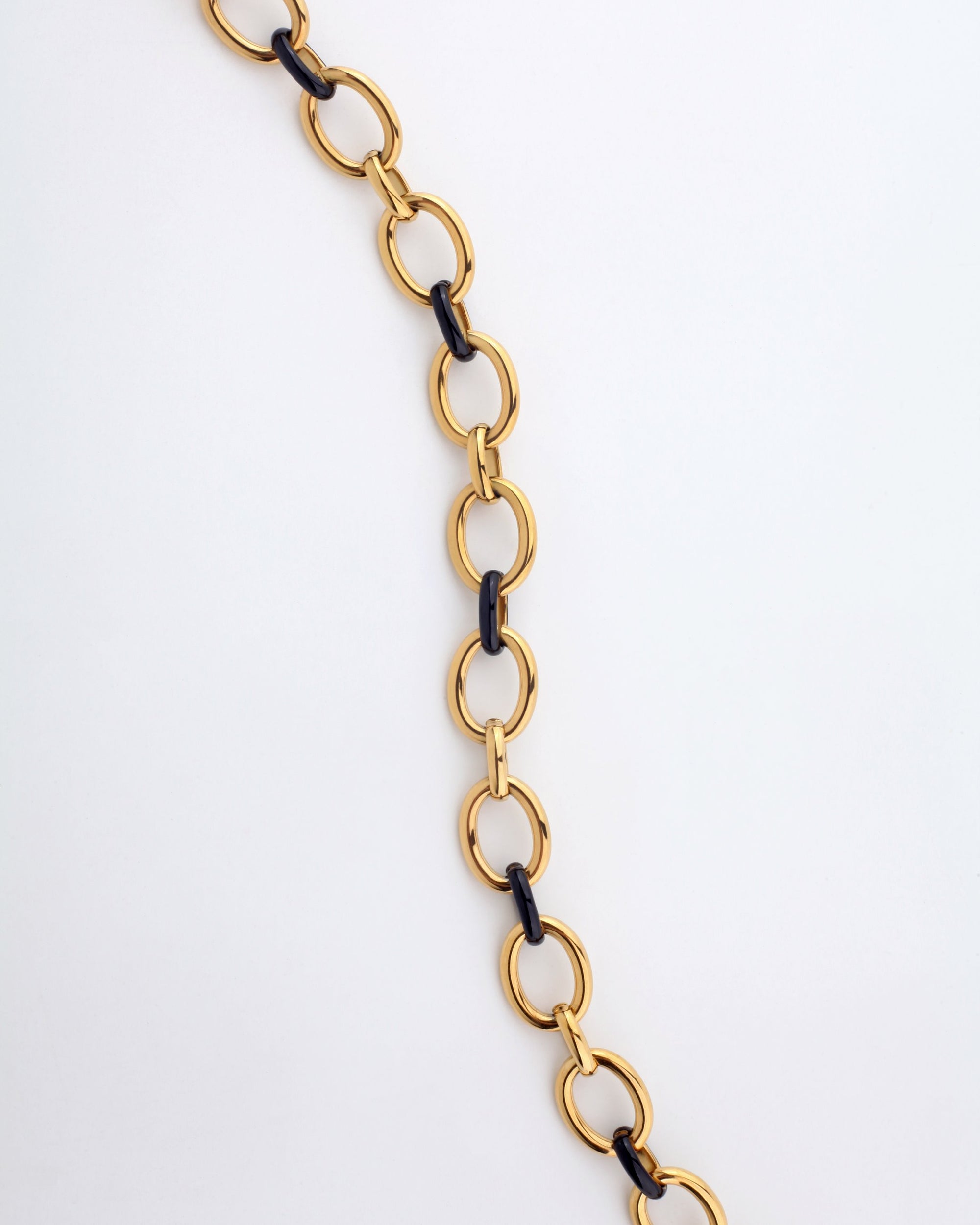 The Raya Necklace by For Art's Sake® features a 45cm chain of alternating gold and black metal oval links, displayed diagonally from top-left to bottom-right against a plain white background.