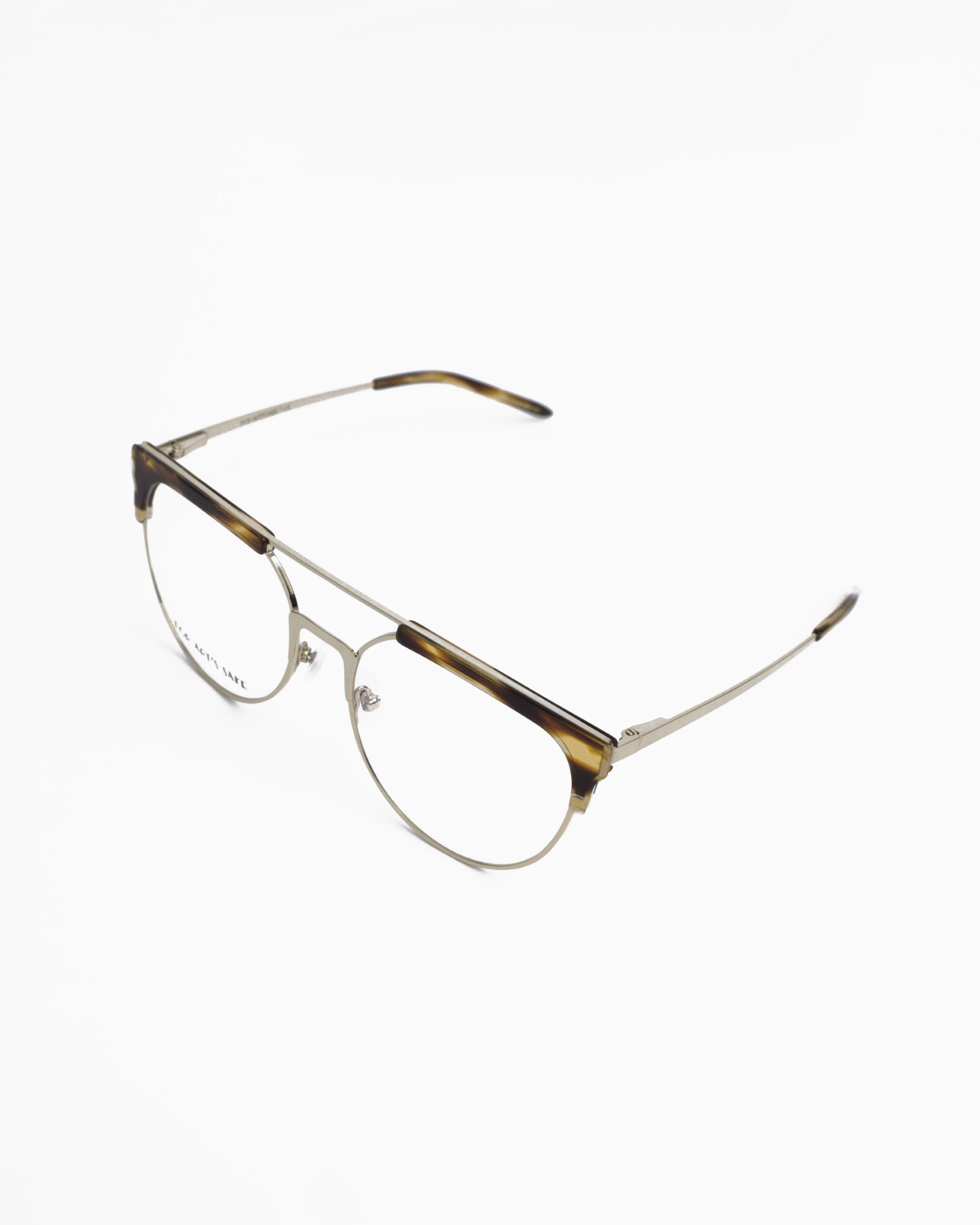 A pair of Frosty by For Art&#39;s Sake® prescription glasses with clear round lenses, thin gold metal frames, and tortoiseshell detailing on the top rims. The temples are thin and gold, with tortoiseshell accents at the tips. These stylish glasses, also equipped with blue light filter technology, are set against a white background.