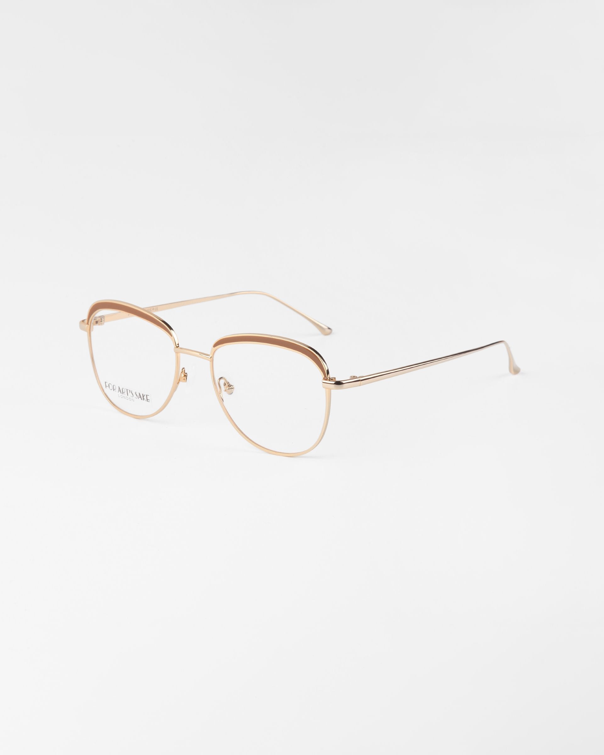 A pair of For Art&#39;s Sake® Smoothie golden, wireframe glasses with clear lenses and 18-karat gold plating. The frames are lightly structured with subtle design elements, offering elegant simplicity. The background is a plain white surface, emphasizing the refined details of these stylish glasses.